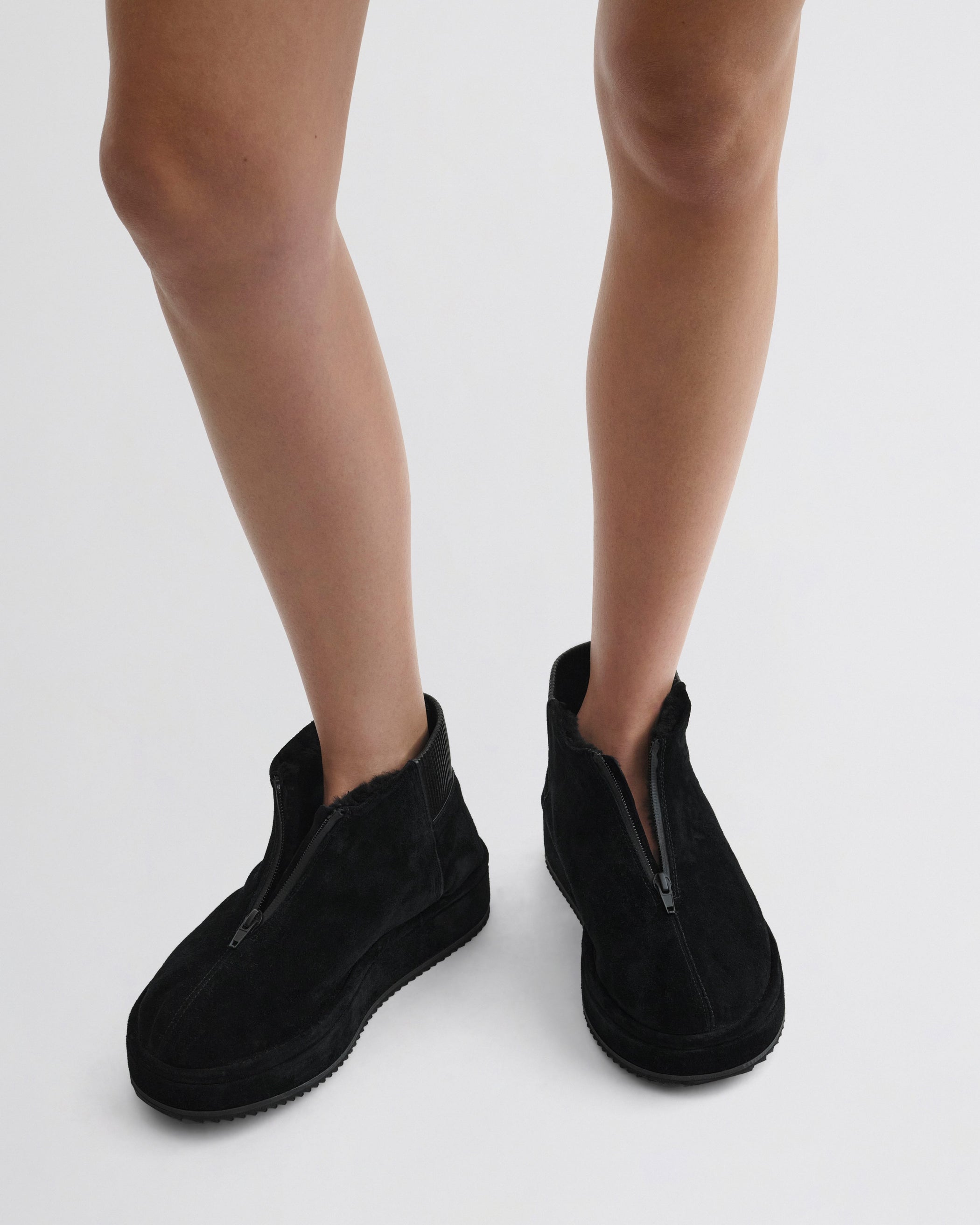 Front view of model wearing Bumper Bootie in black leather