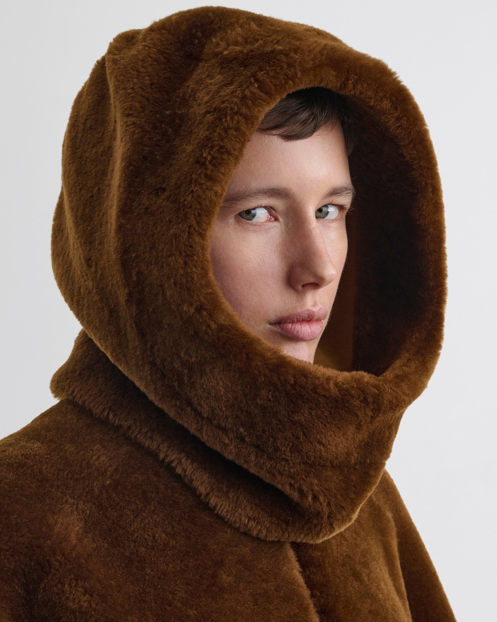 Front view of model wearing Capoosh in ginger shearling