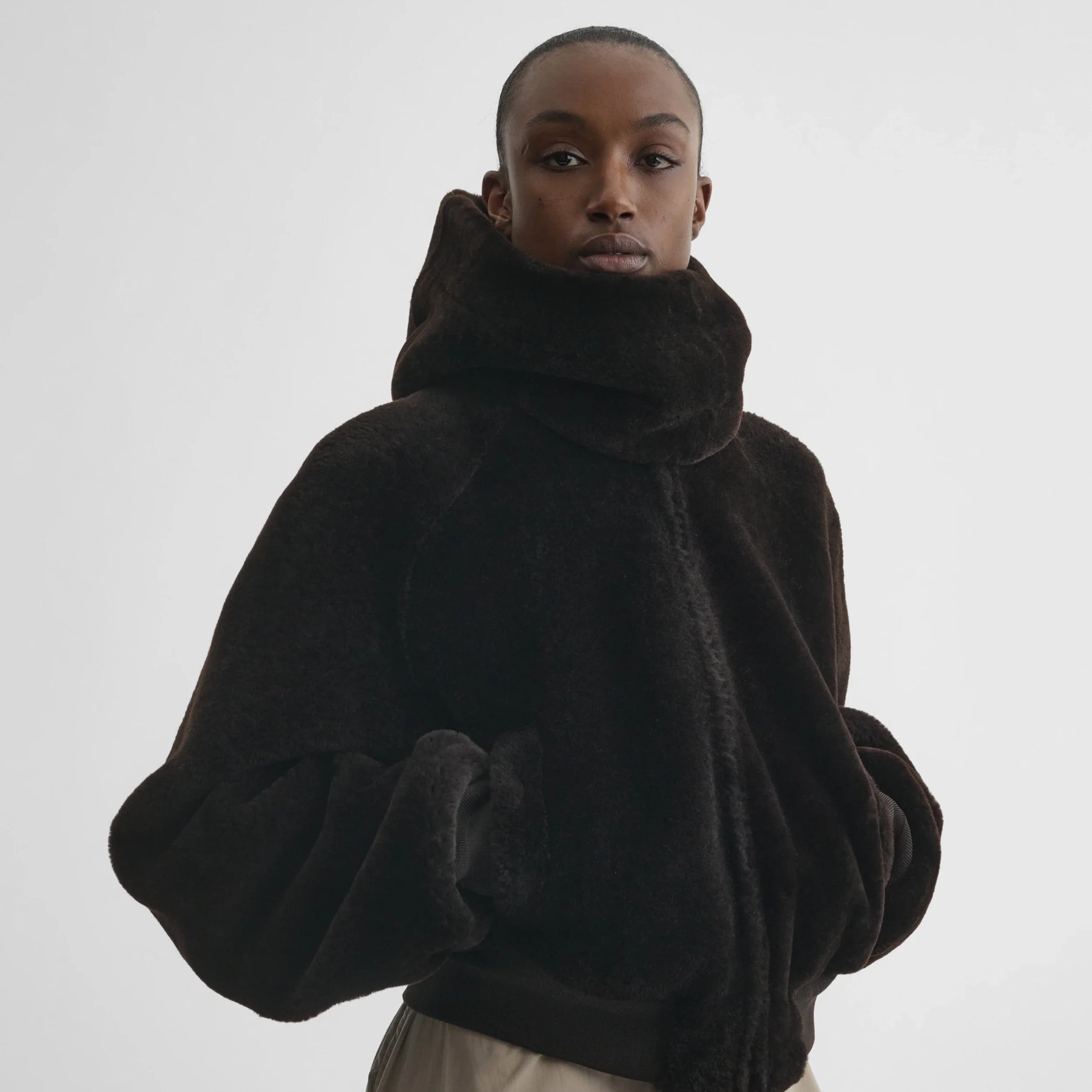 Front view of model wearing Capoosh in brown shearling