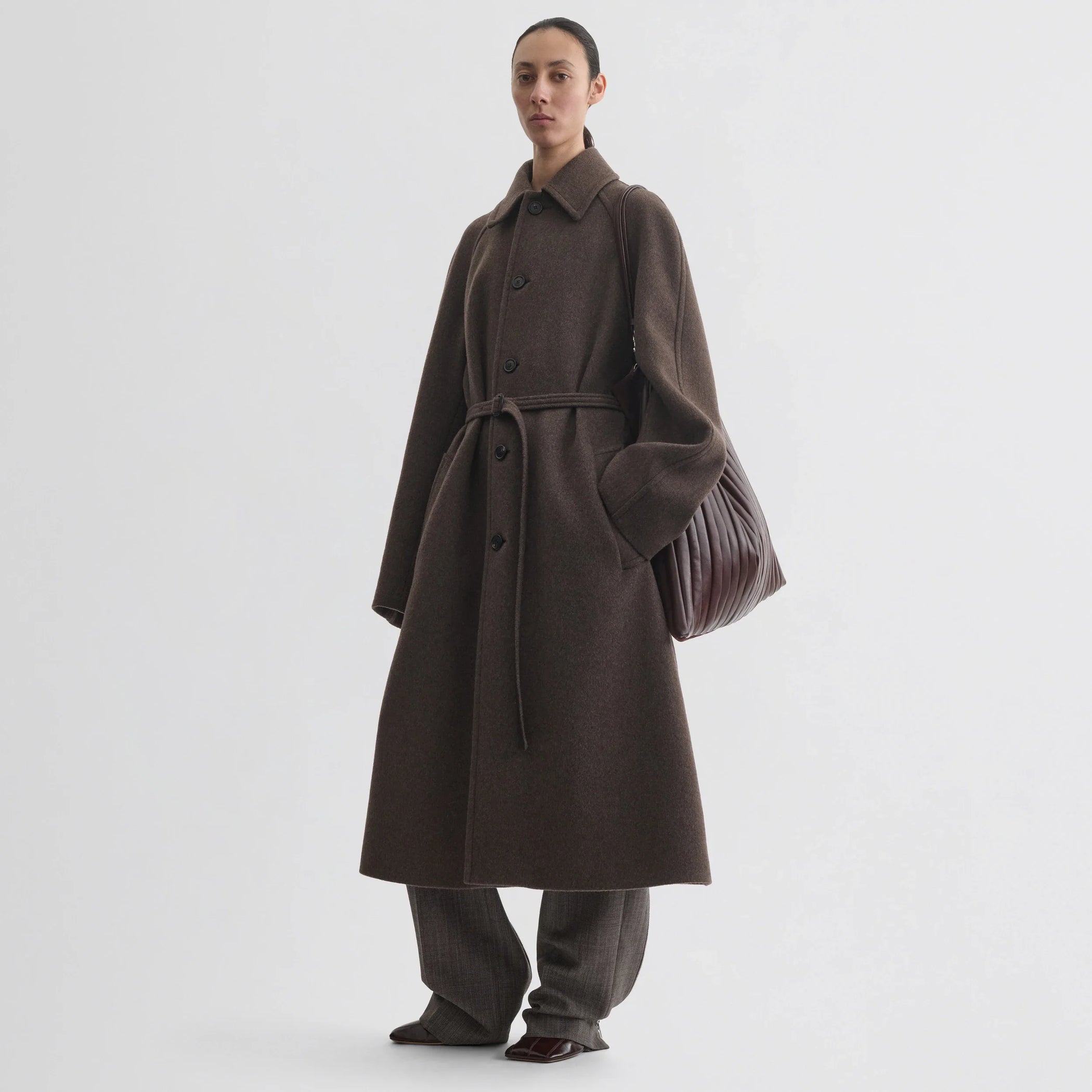Front view of model wearing curve shoulder coat in brown cashmere.