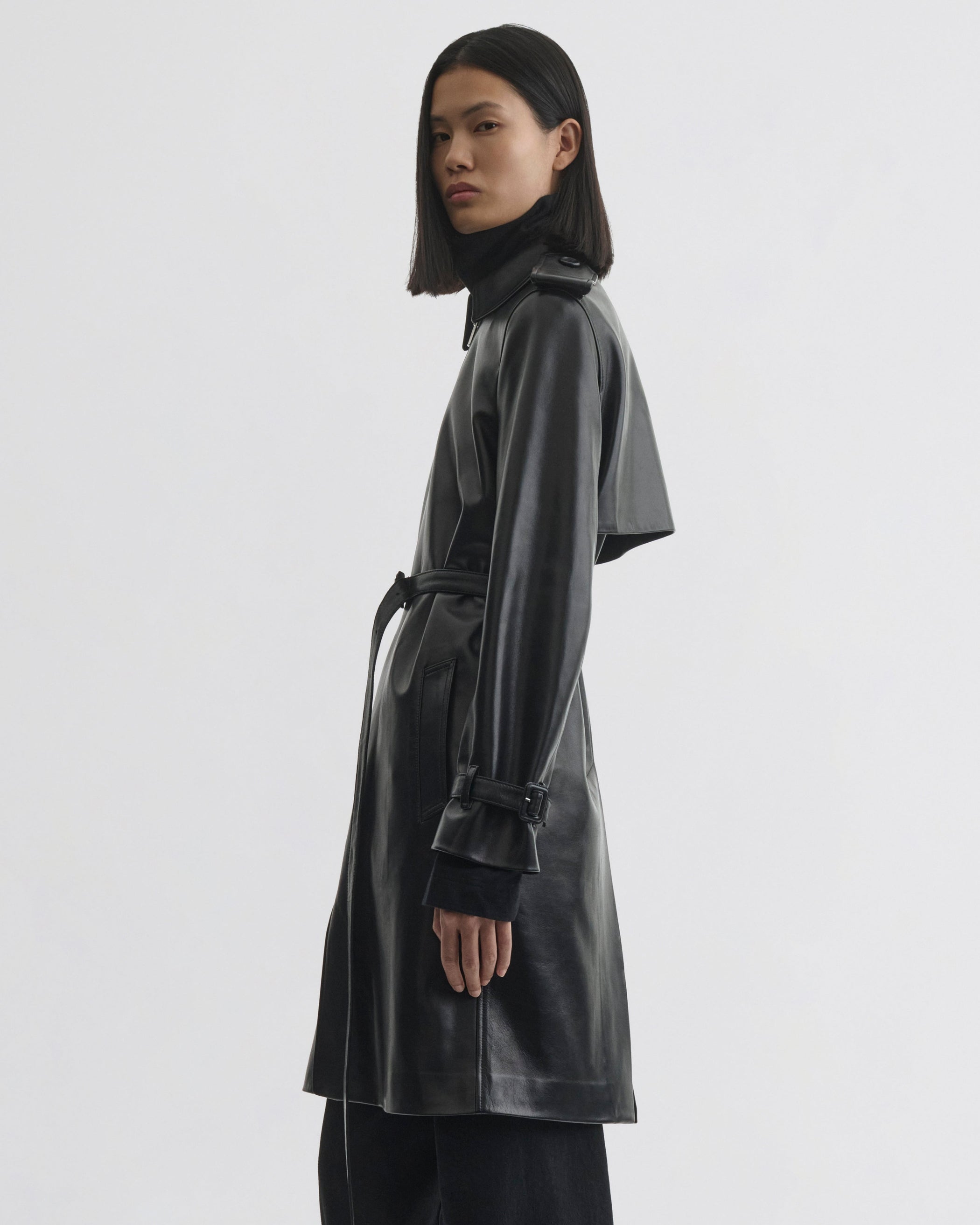 Side view of model wearing Short Trench in black leather