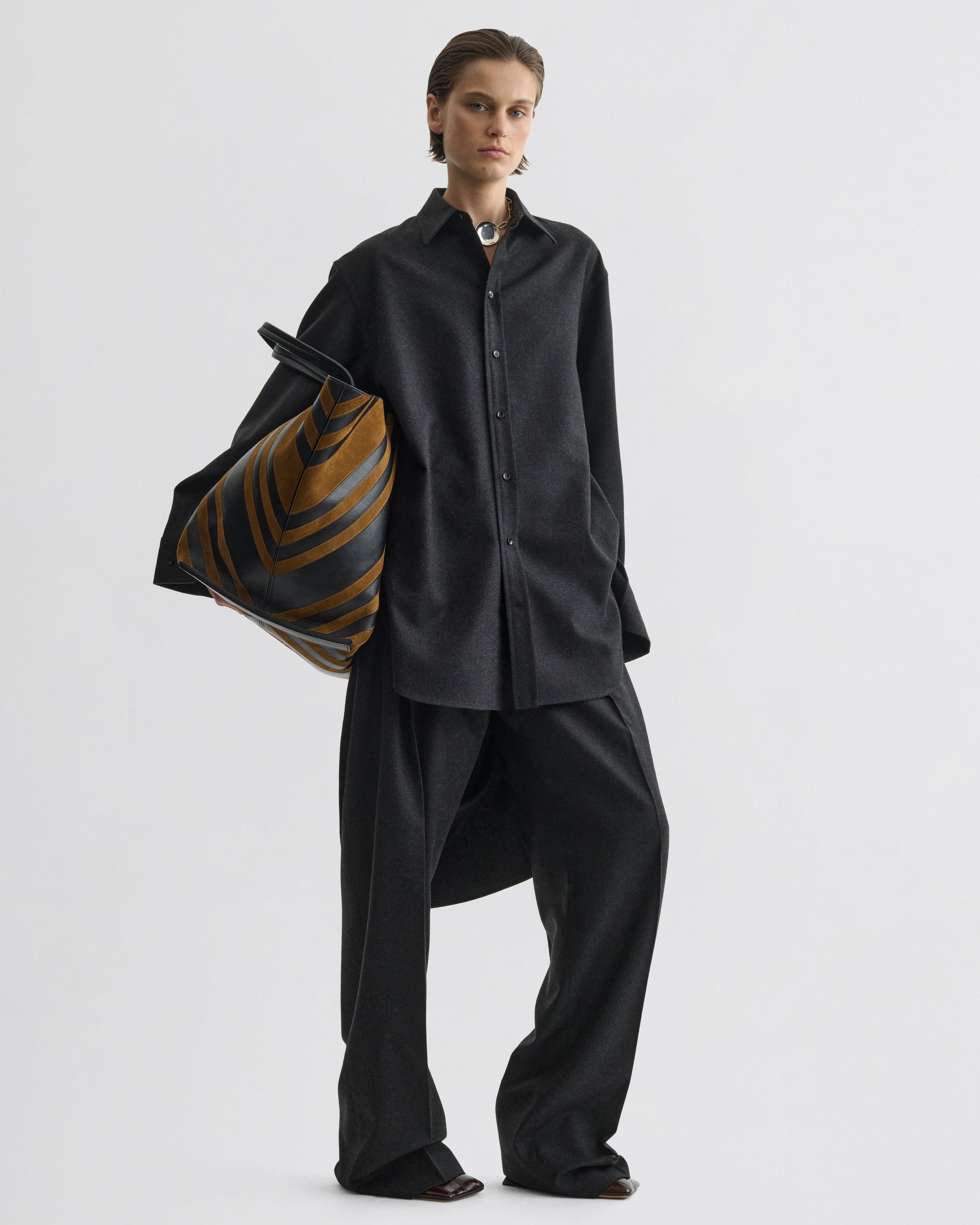 Front view of model wearing Double Pleat Trousers in charcoal wool