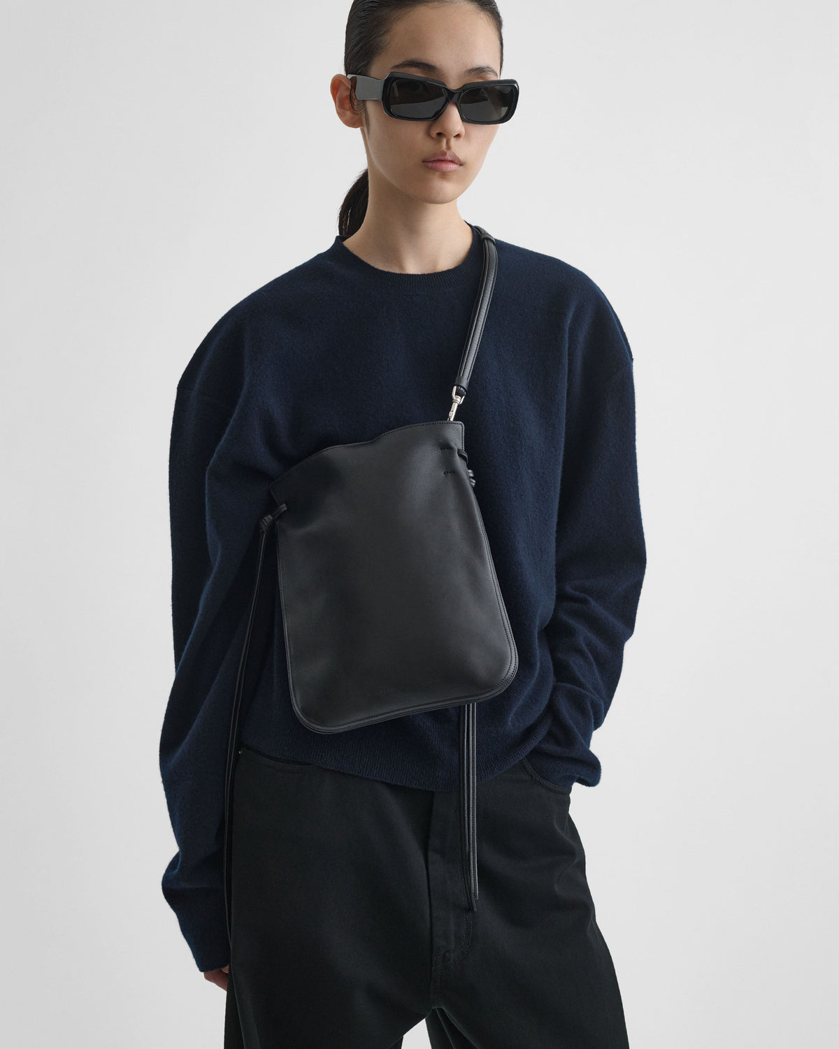 Front view of model wearing GIG POUCH in black leather