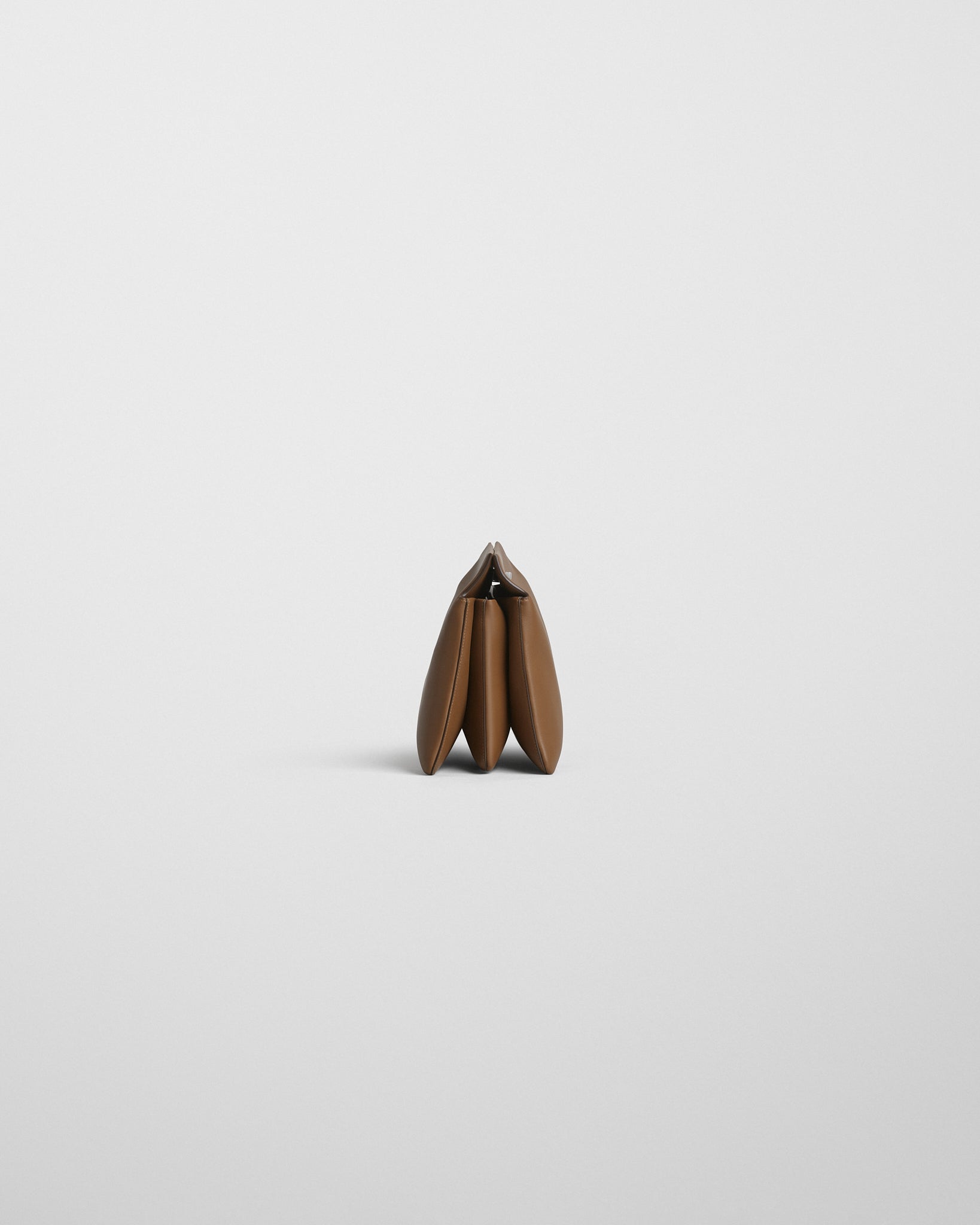 Side view of TRIPLEX CLUTCH in caramel leather.