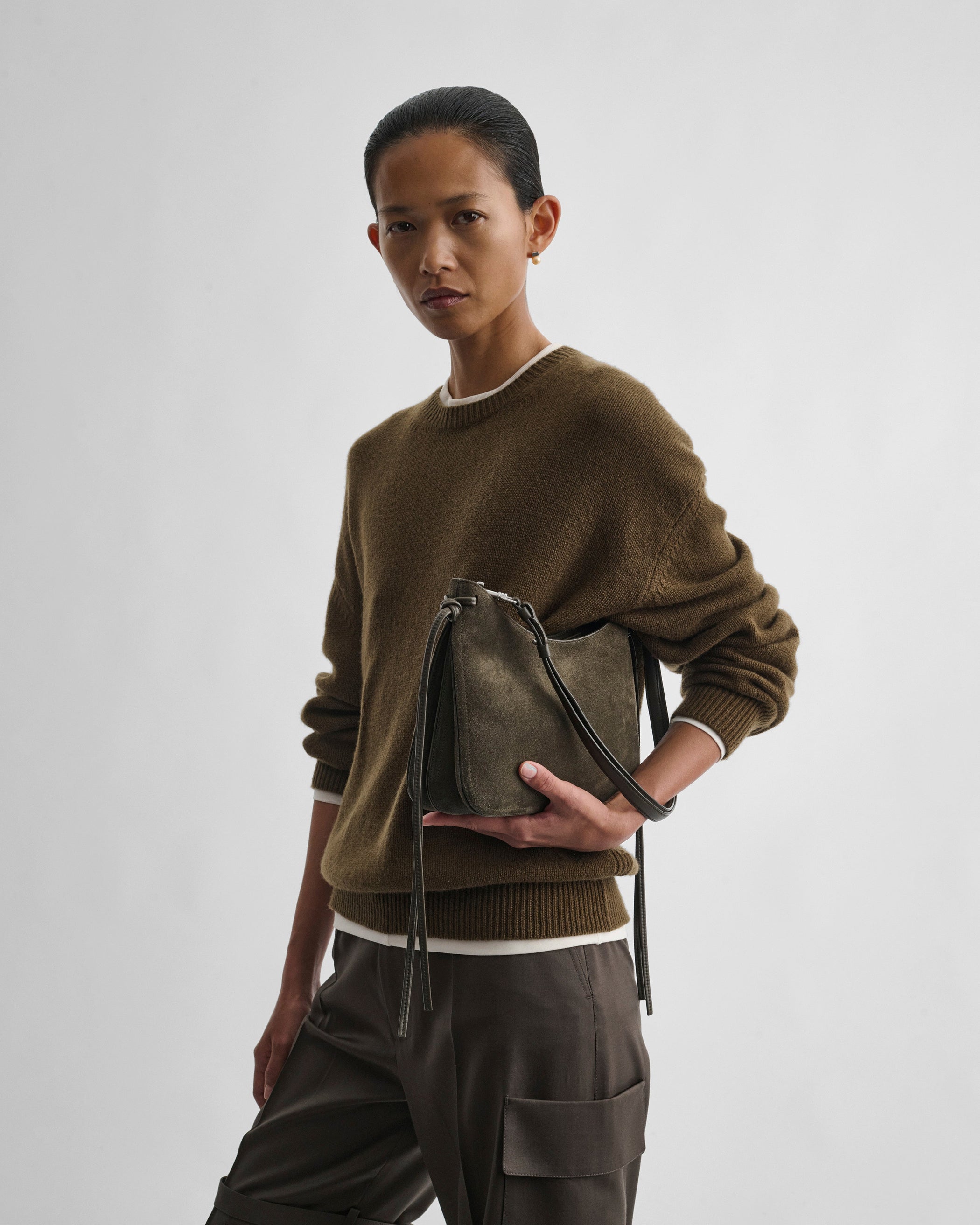 Front view of model holding SMALL GIG BAG in sage suede