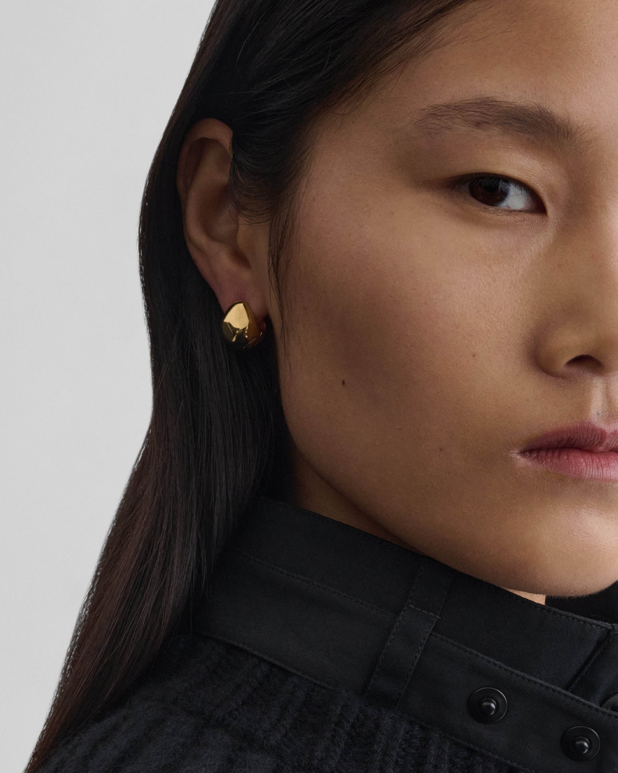 Model wearing PEBBLE STUD EARRINGS in gold plated sterling silver