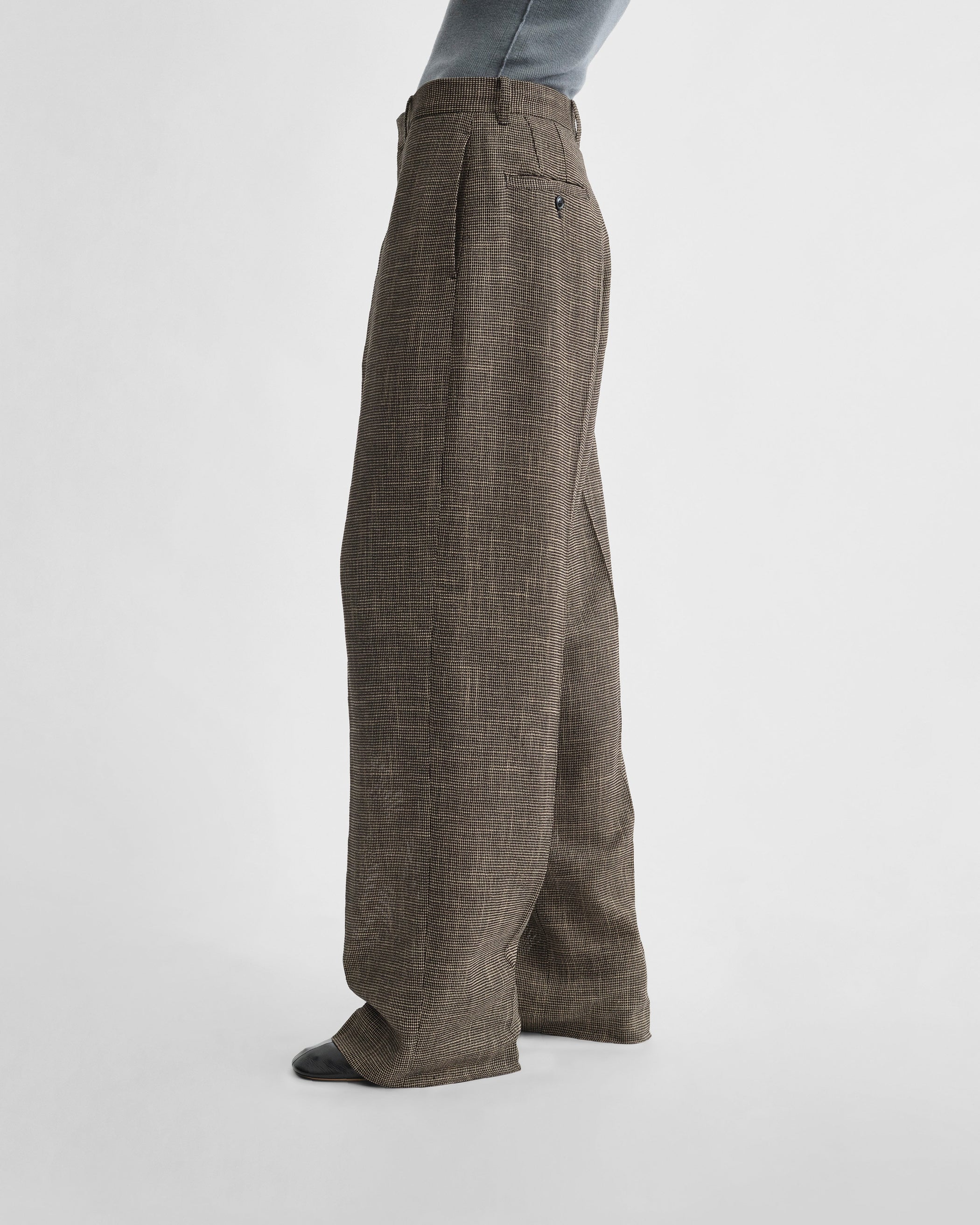 Side view of model wearing DROP TROUSERS in salt and pepper melange woven viscose