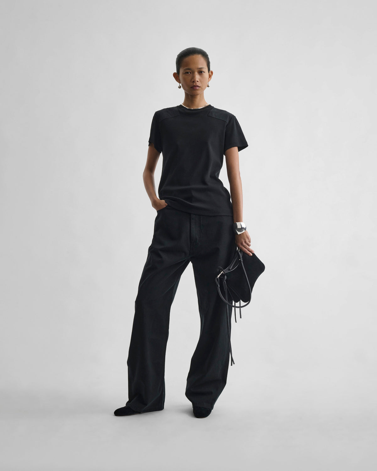 Front view of model wearing DROP JEANS in black cotton