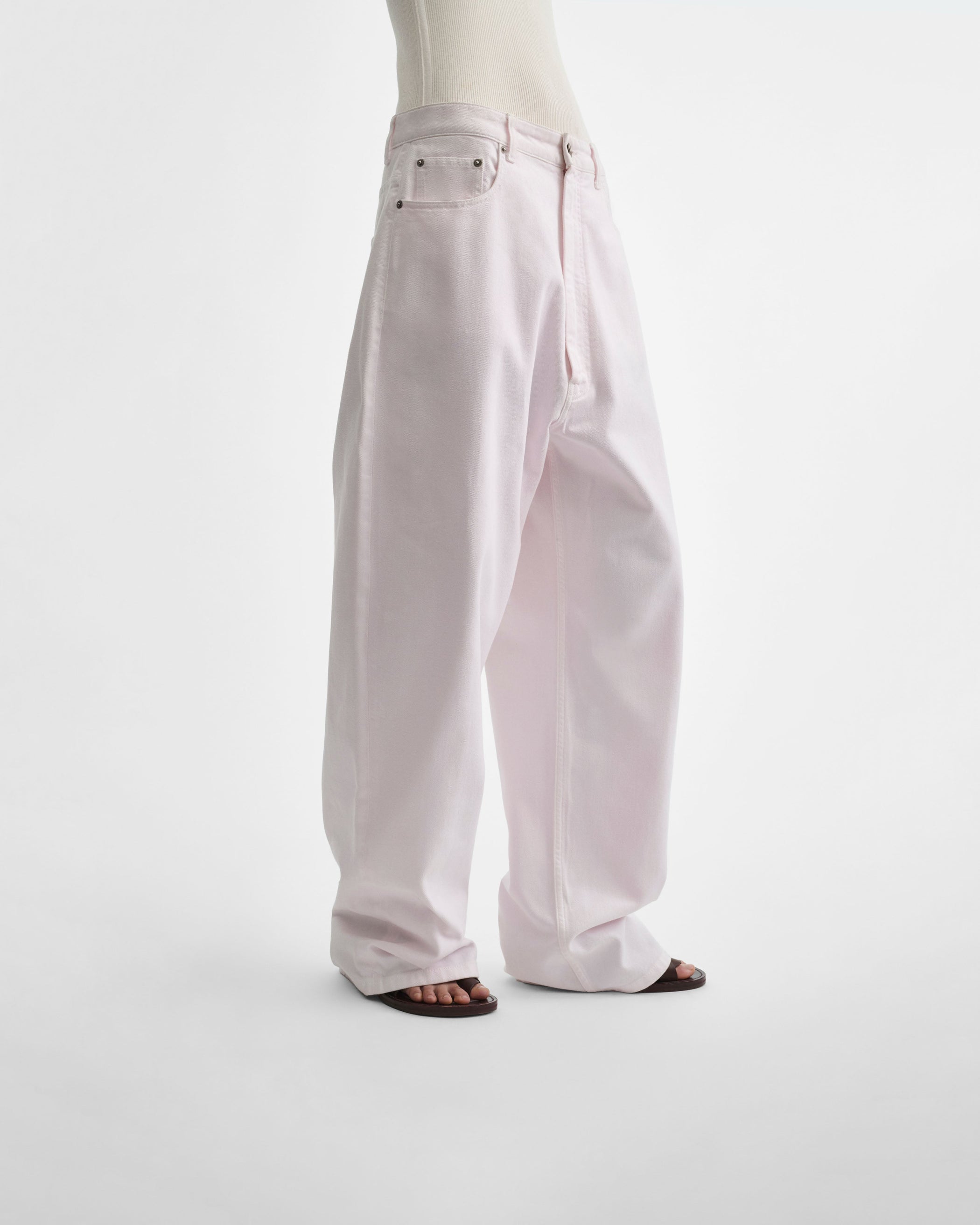Angled front view of model wearing DROP JEANS in pale pink pink