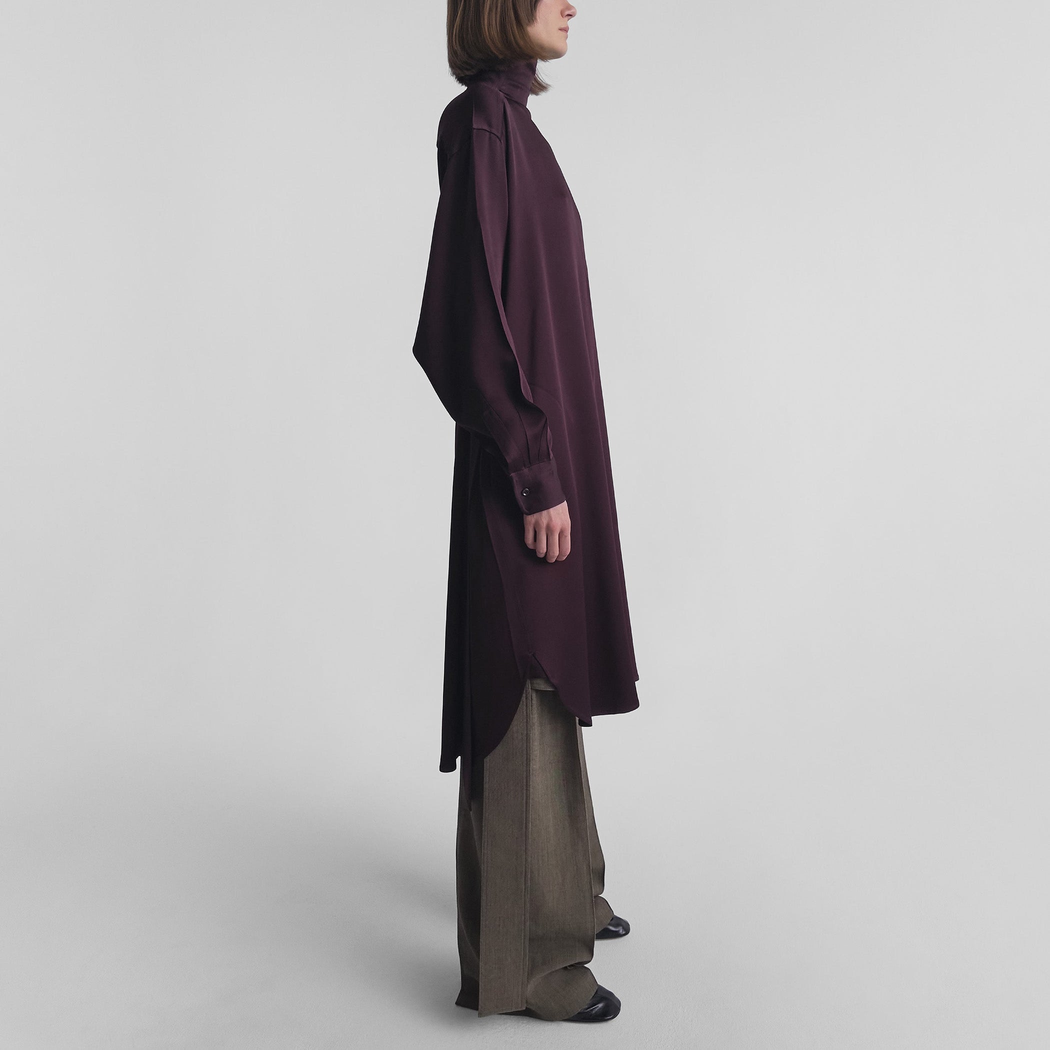 Side view of model wearing DRESS in dark berry satin back crepe