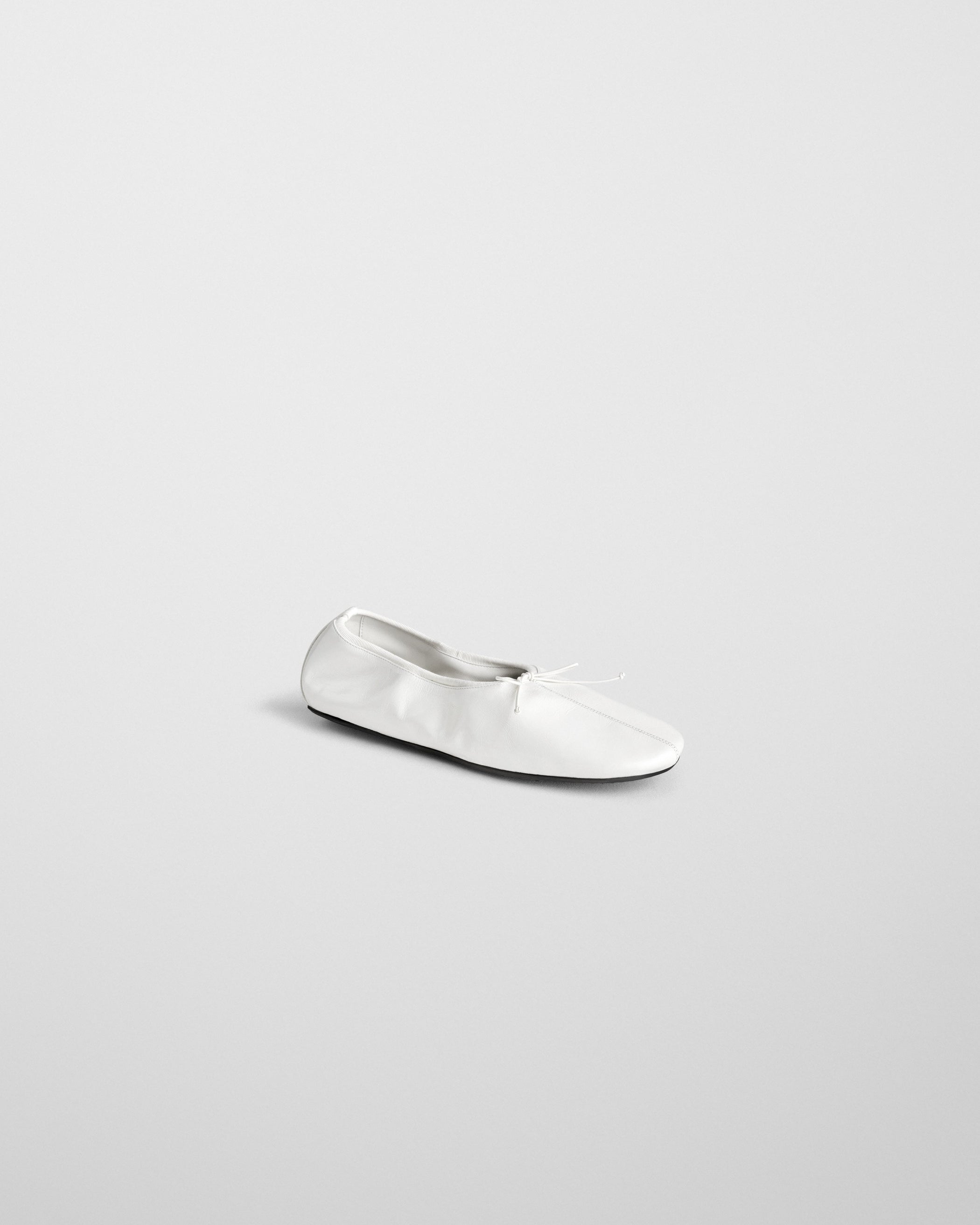 Angled side view of GATHERED FLAT in white leather