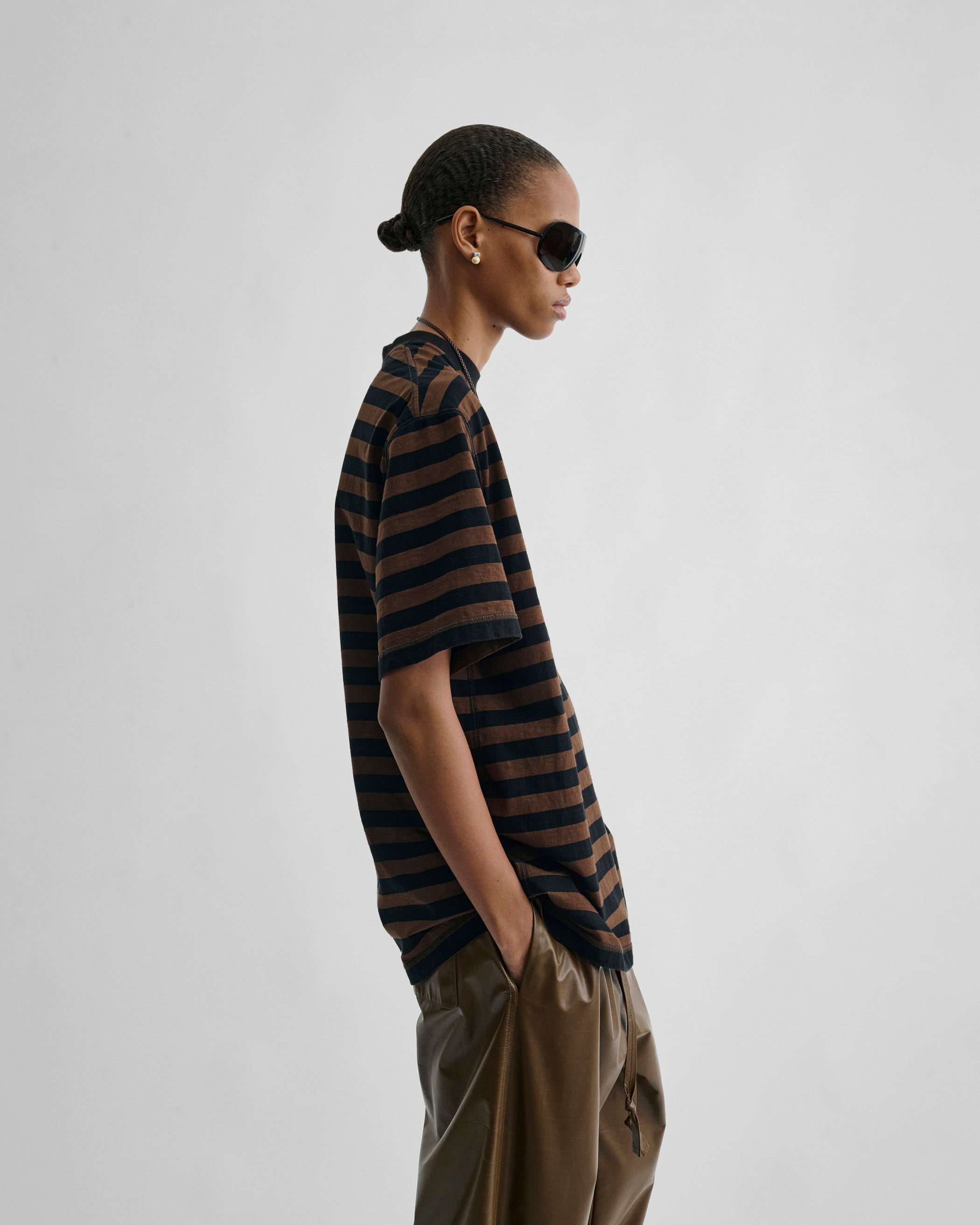 Side view of model wearing CLASSIC TEE in black/brown cotton