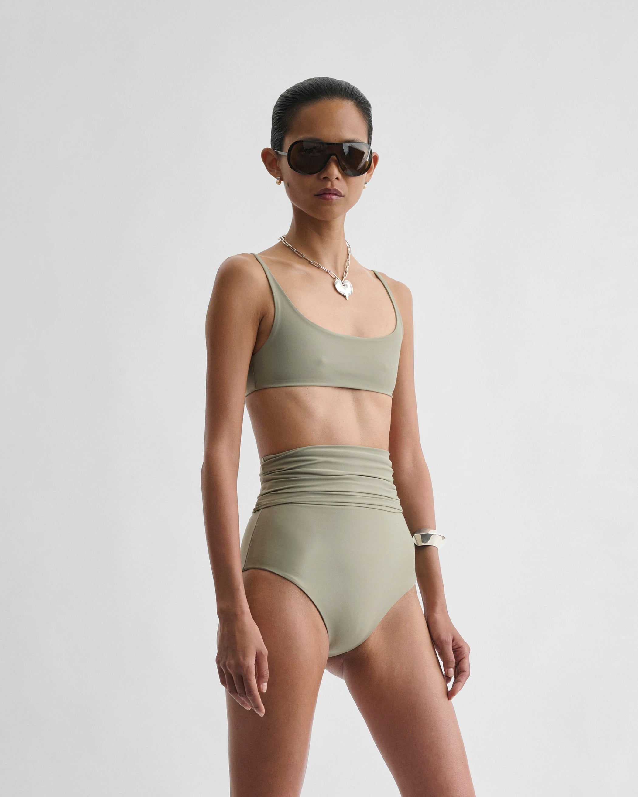Angled front view of model wearing FOLD DOWN BIKINI BOTTOMS in light sage polyamide