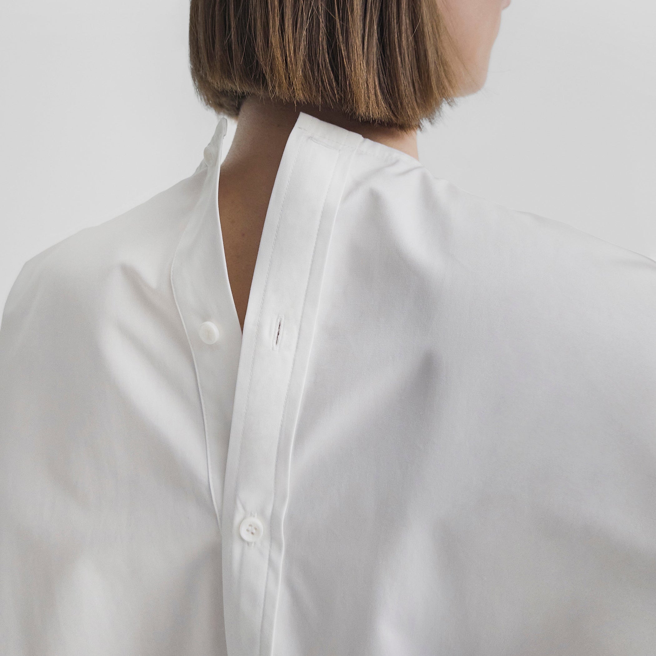 Close up detail view of model wearing T-SHIRT in white cotton shirting