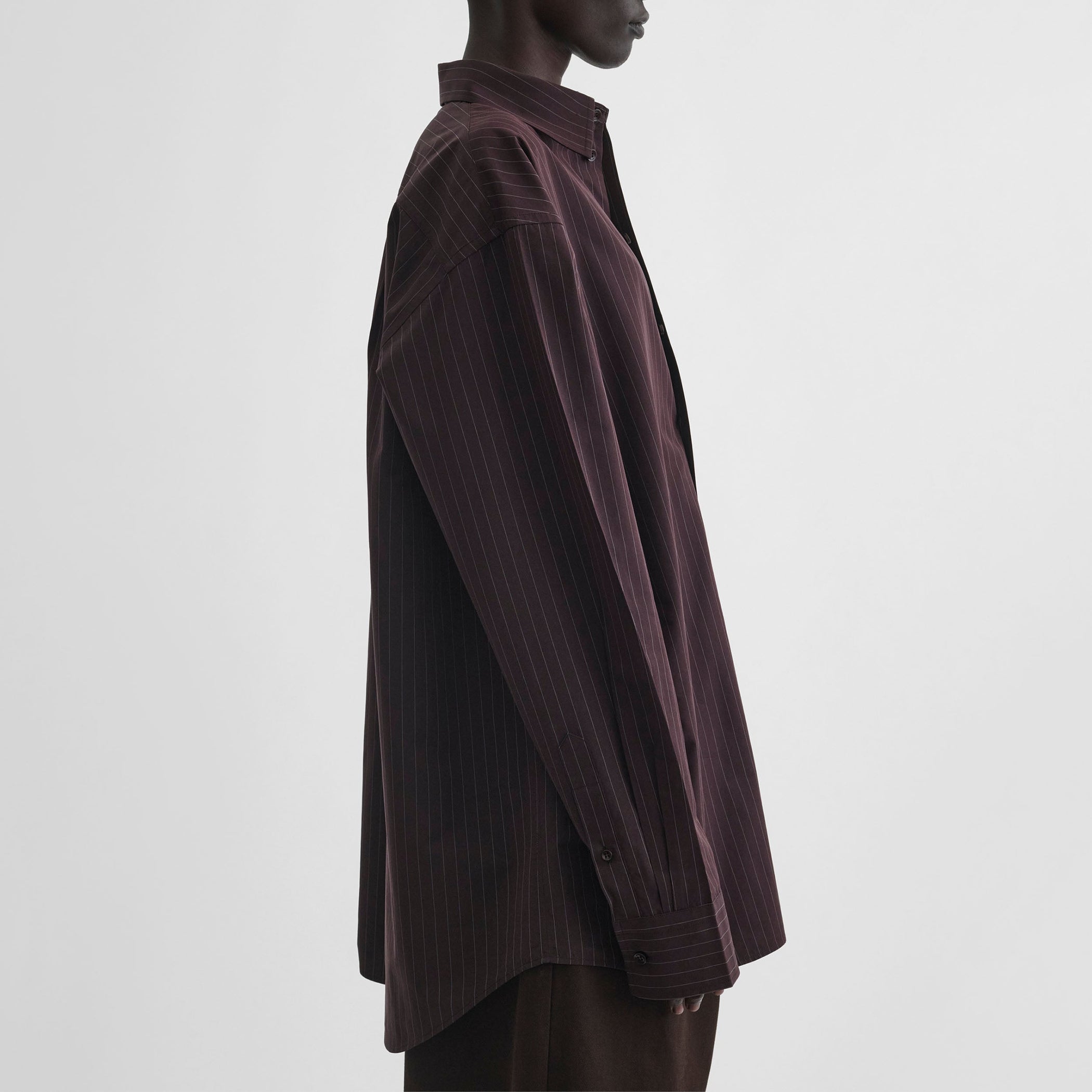 Side view of model wearing sharp collar shirt in black cherry pinstripe cotton