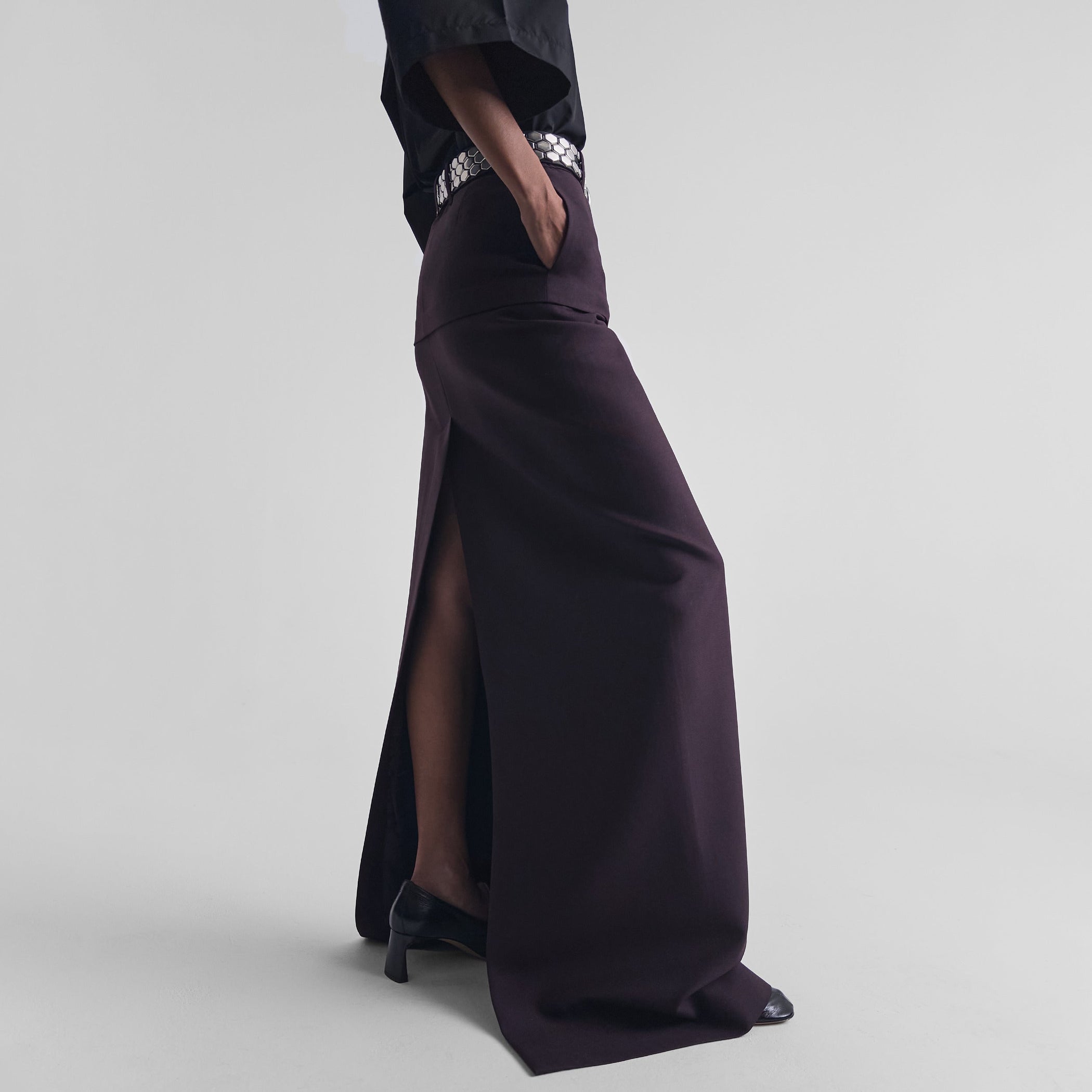 Side view of model wearing HIGH SLIT TAILORED COLUMN SKIRT in berry wool