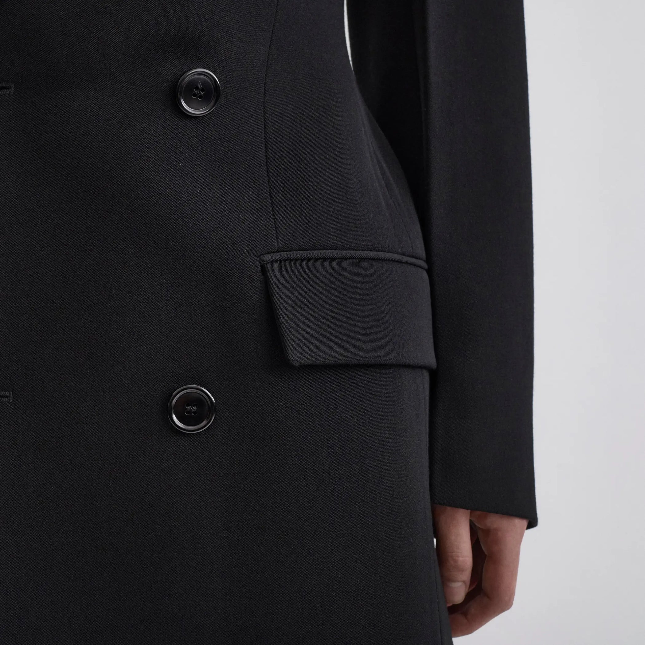 Close up detail view of model wearing TAILORED COAT WITH DROPPED WAIST in black wool