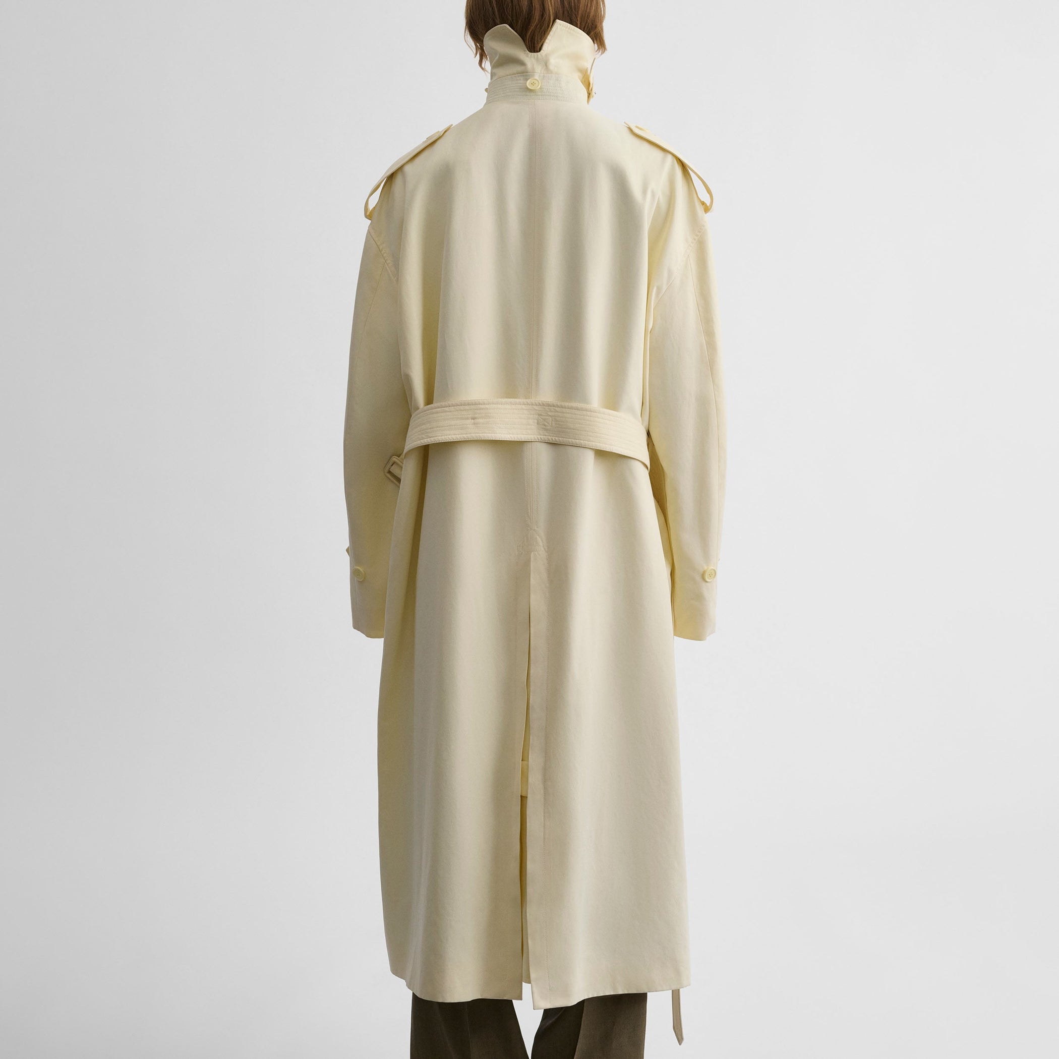 Back view of model wearing TRENCH COAT WITH ATTACHABLE SCARF in cream technical polyester