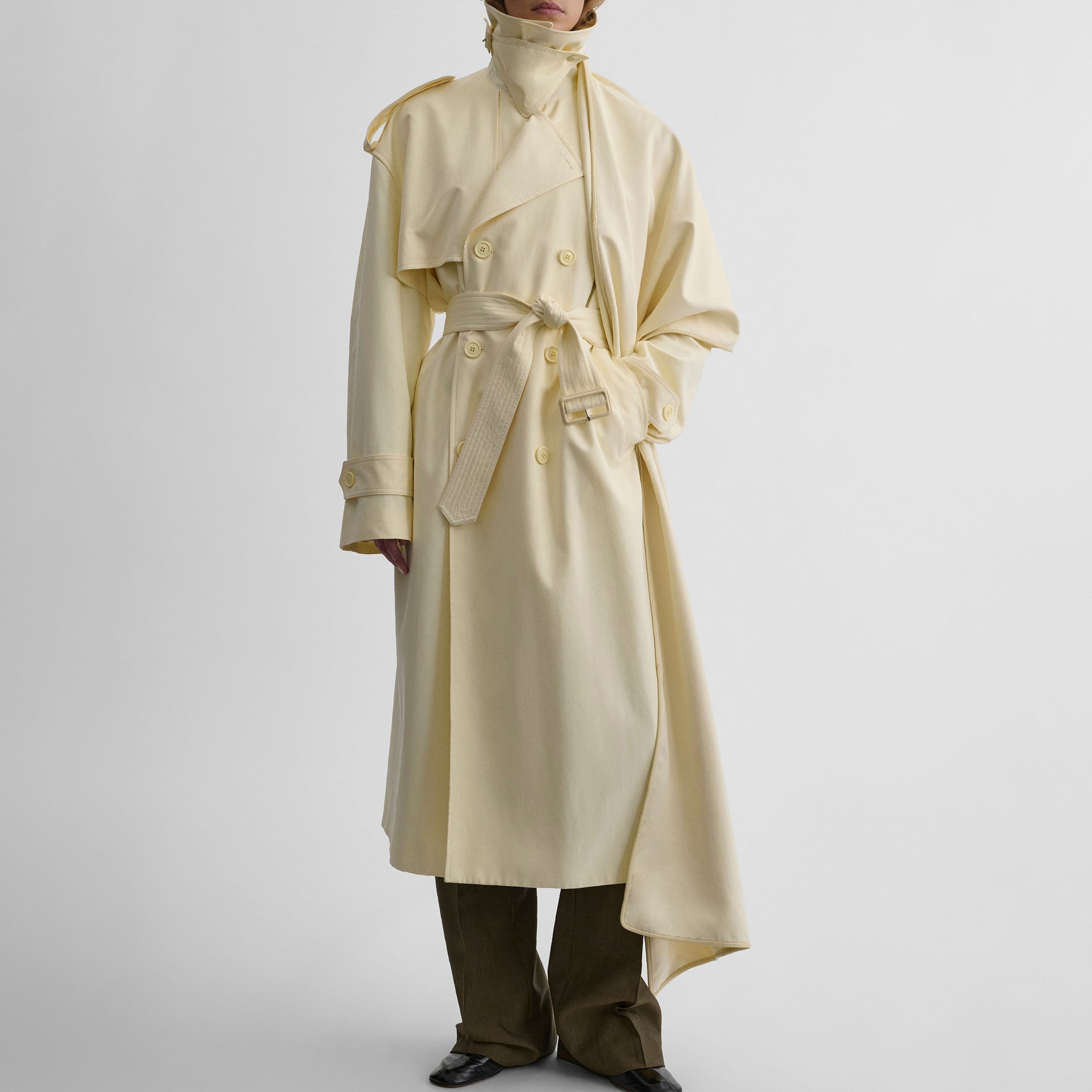Front view of model wearing TRENCH COAT WITH ATTACHABLE SCARF in cream technical polyester