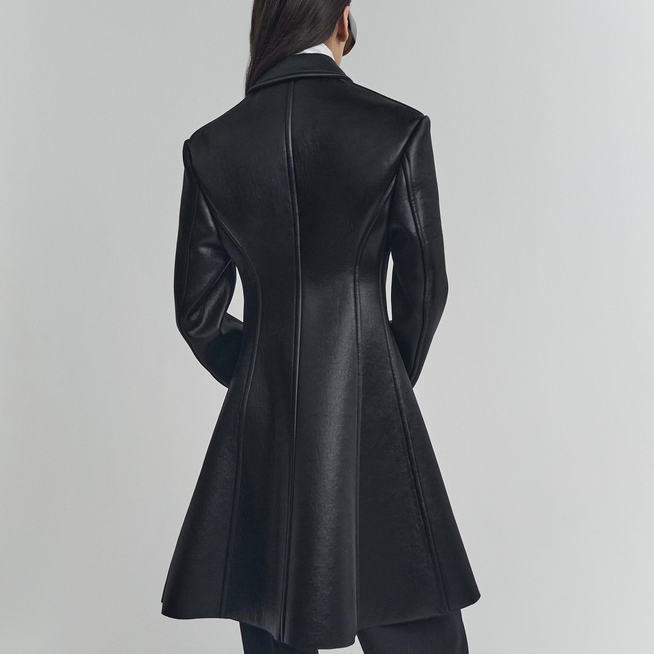 Back view of model wearing SHORT COAT in black bonded satin