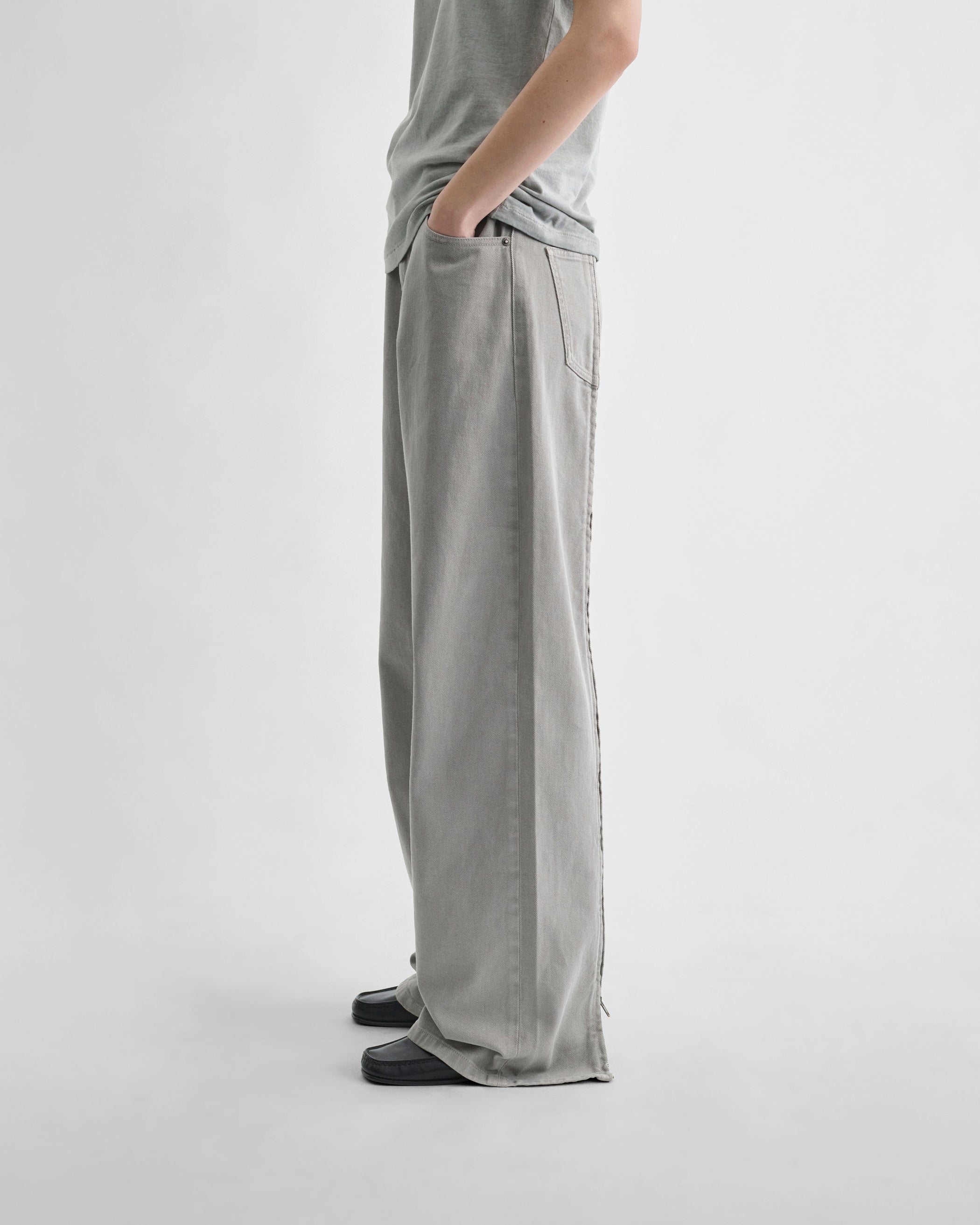 Side view of model wearing ZIP JEANS in ash grey cotton