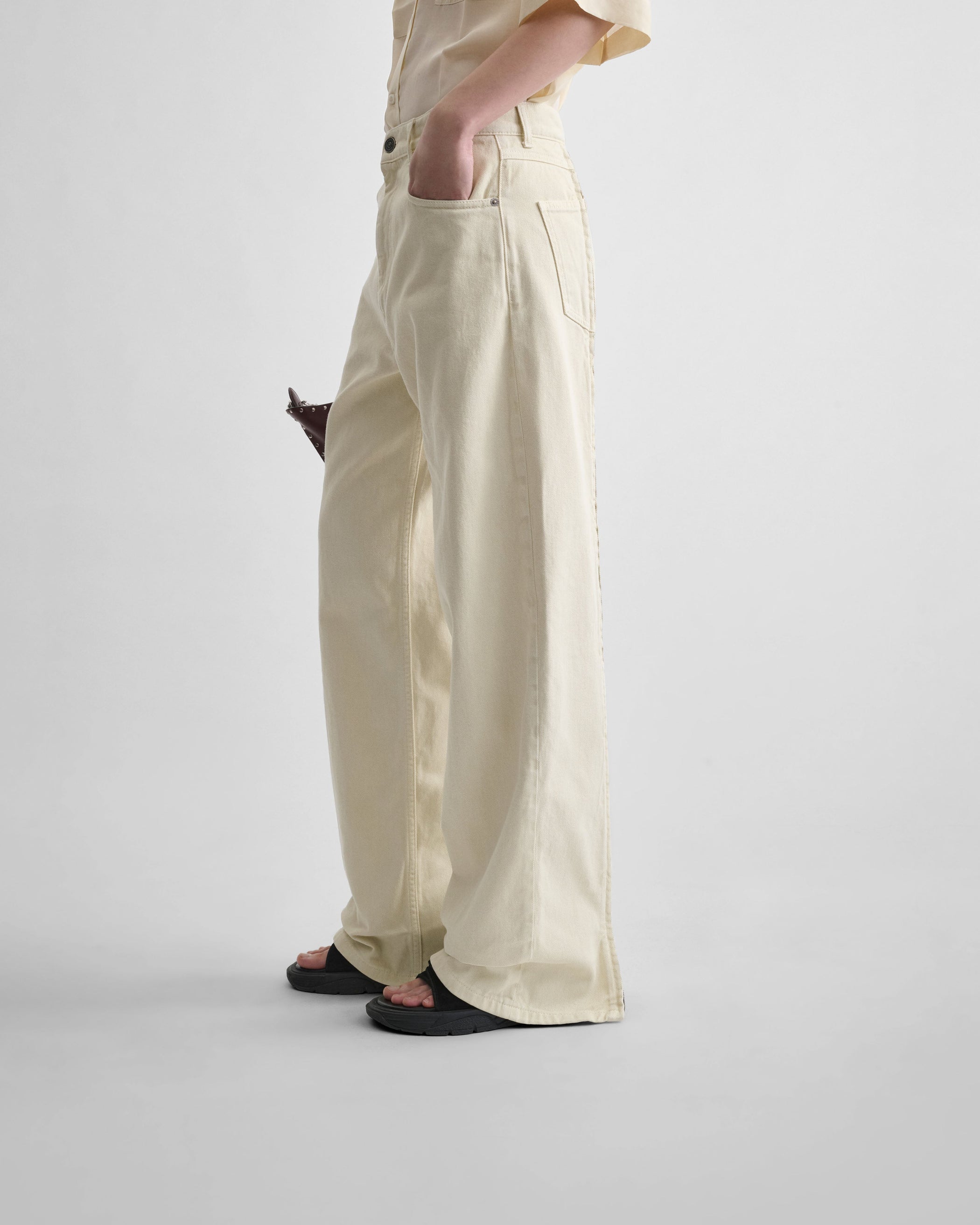 Side view of model wearing ZIP JEANS in pistachio cotton