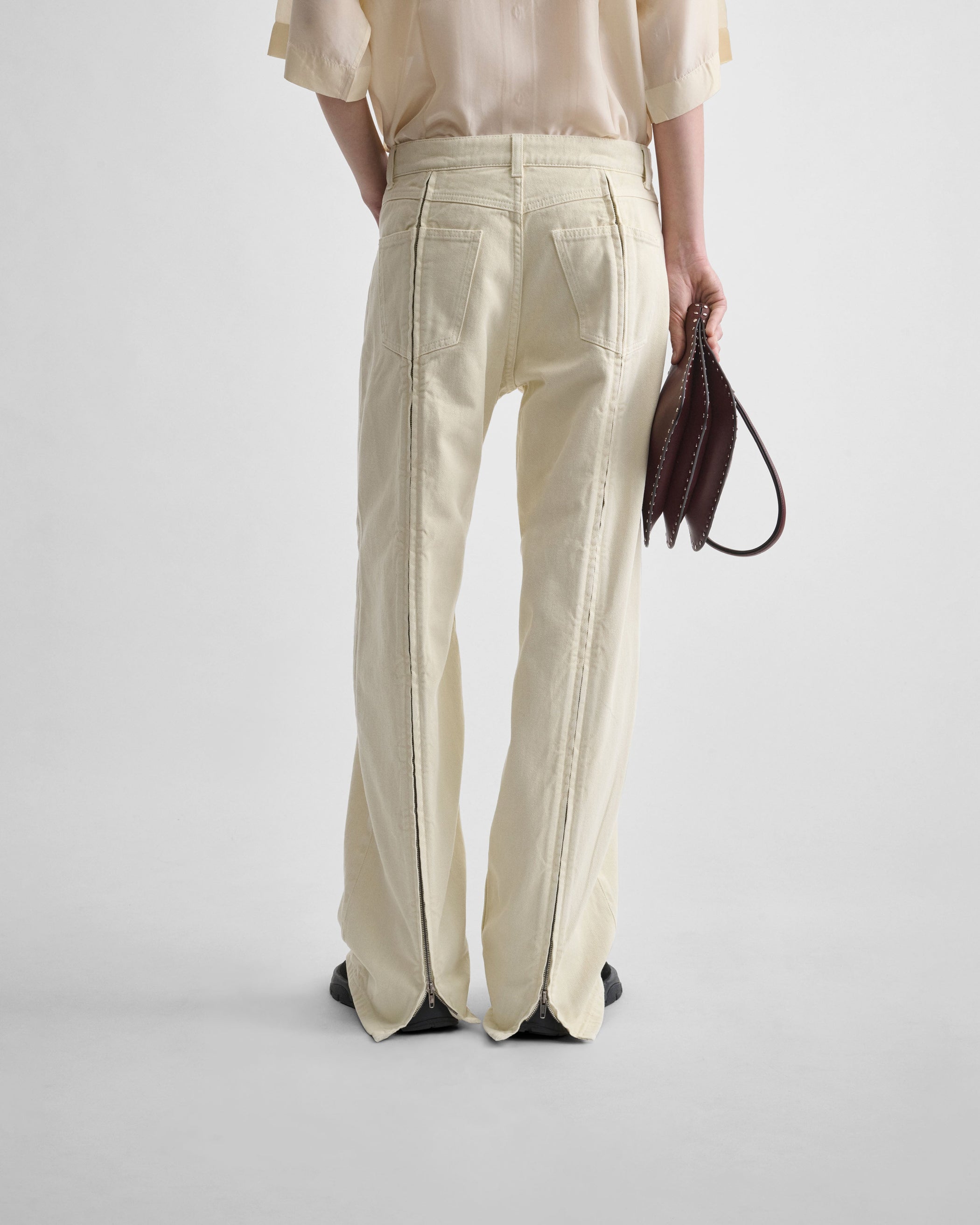 Back view of model wearing ZIP JEANS in pistachio cotton