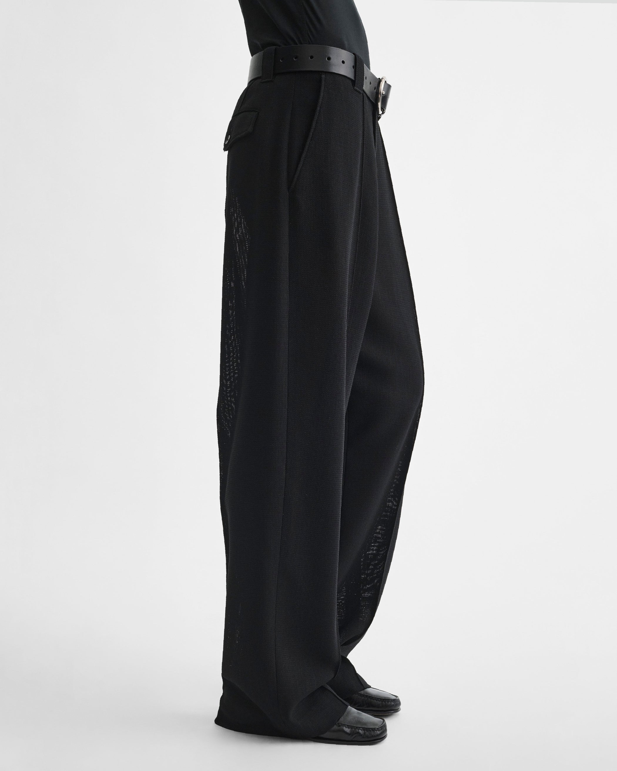 Side view of model wearing OVERSIZED TROUSERS in black viscose