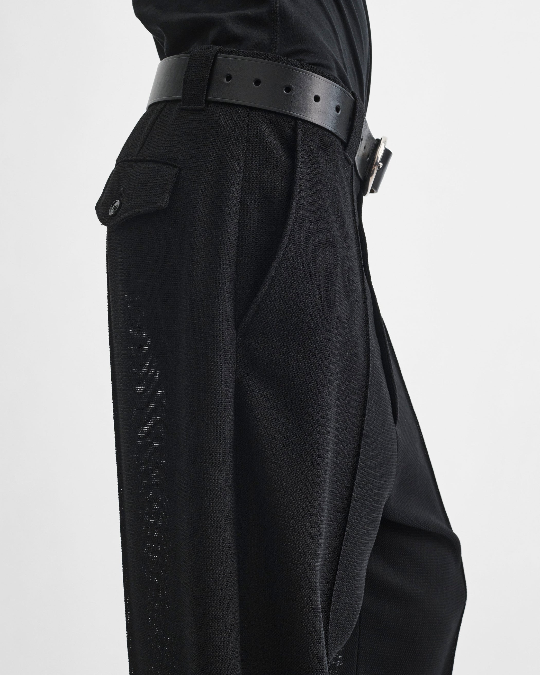 Detail side view of model wearing OVERSIZED TROUSERS in black viscose