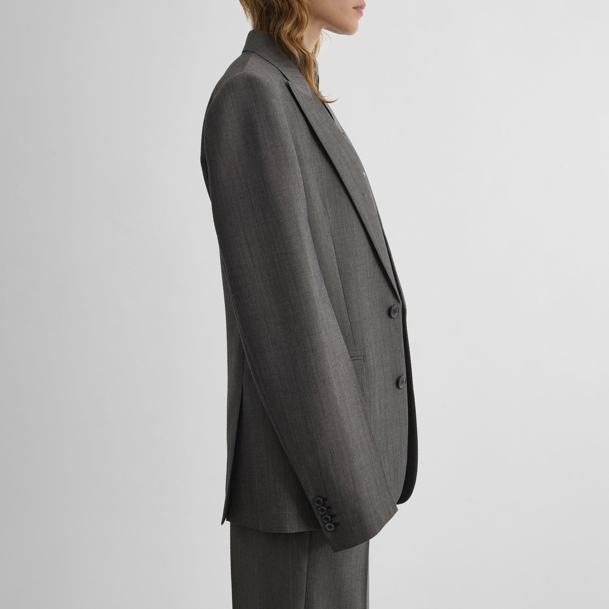 Side view of model wearing SINGLE BREASTED JACKET in dark taupe wool