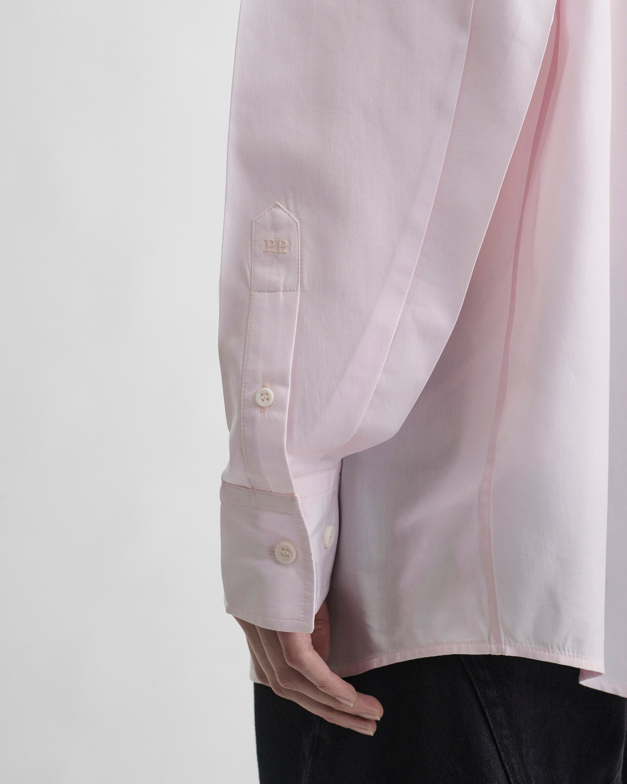 Detail view of model wearing BUTTON COLLAR SHIRT in pale pink cotton