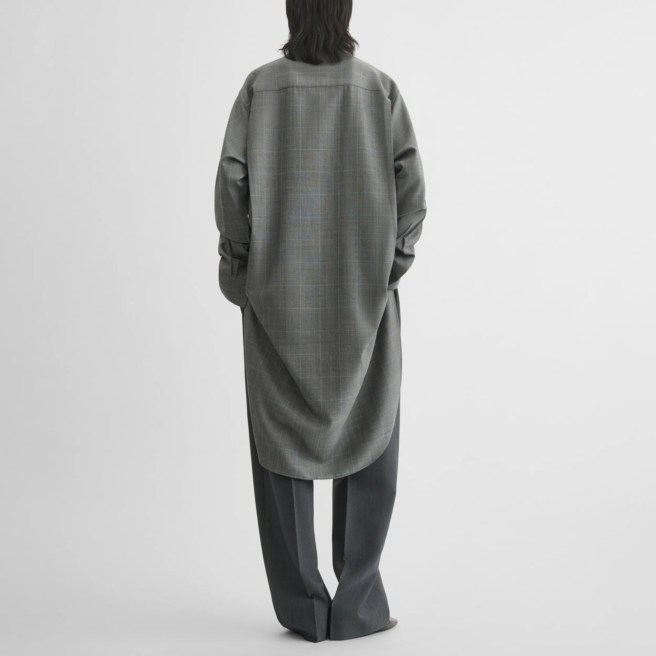 Back view of elongated shirt in black-blue wool