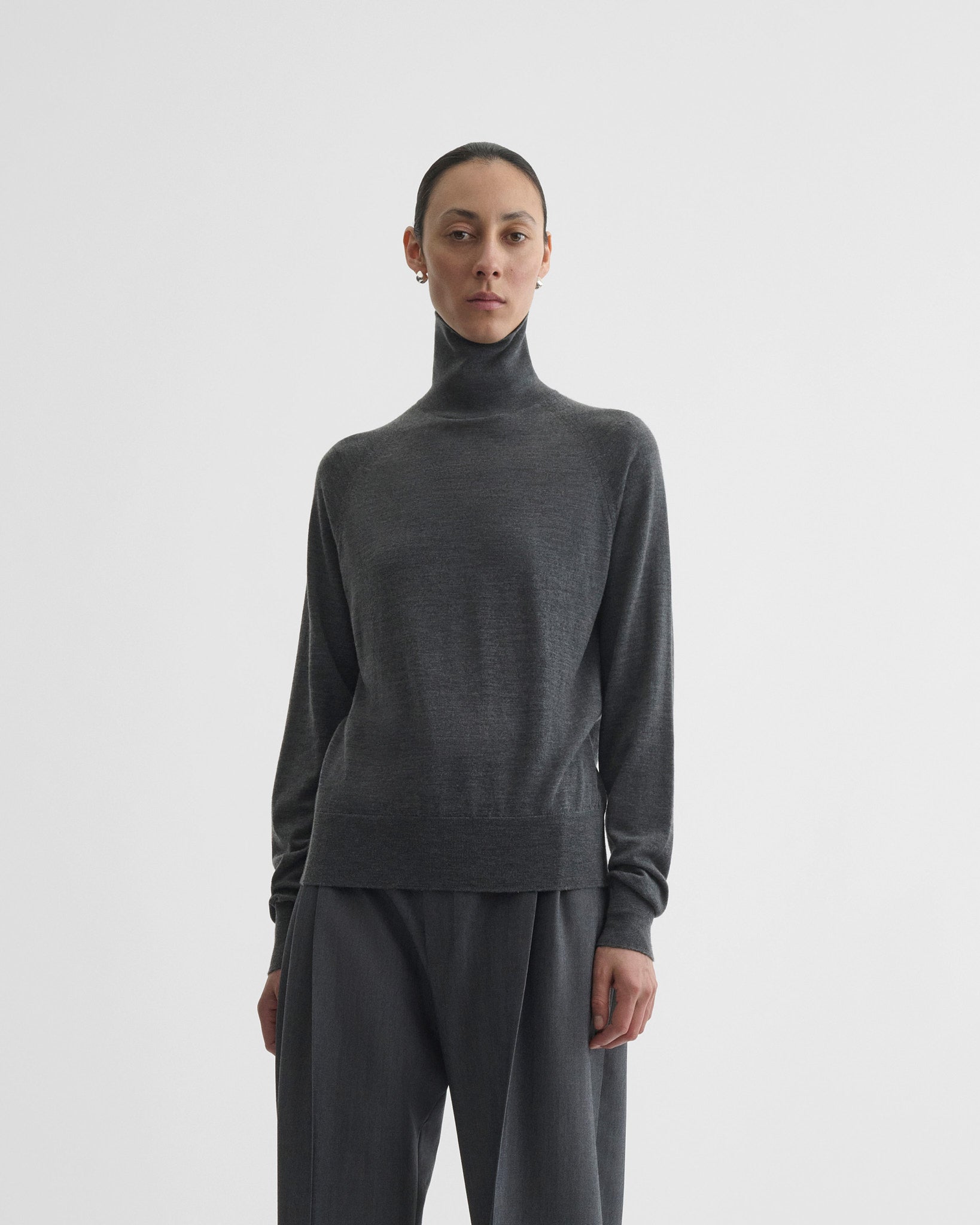 Front view of model wearing high neck jumper in anthracite-melange wool