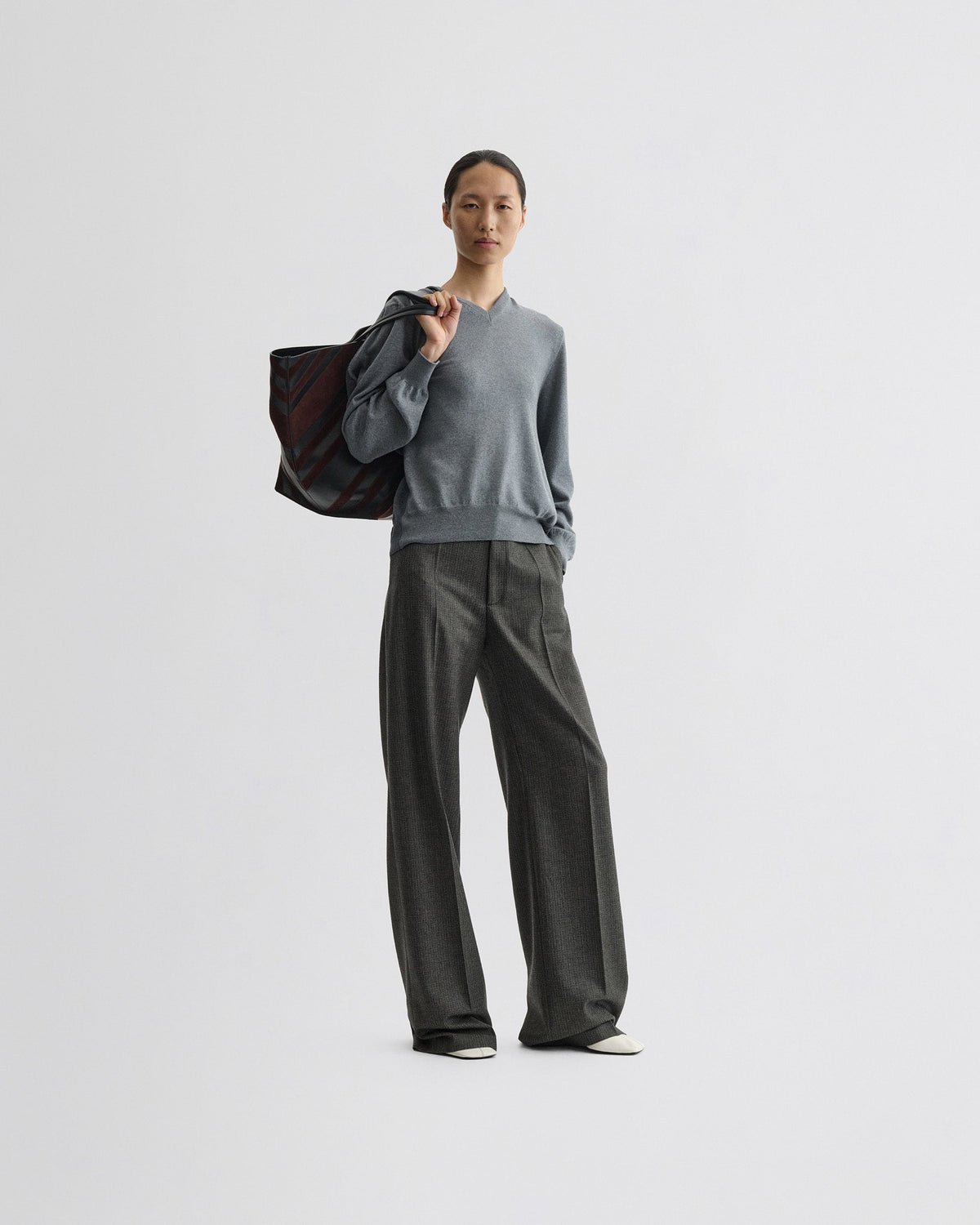 Front view of model wearing BACKED V NECK SWEATER in light grey wool