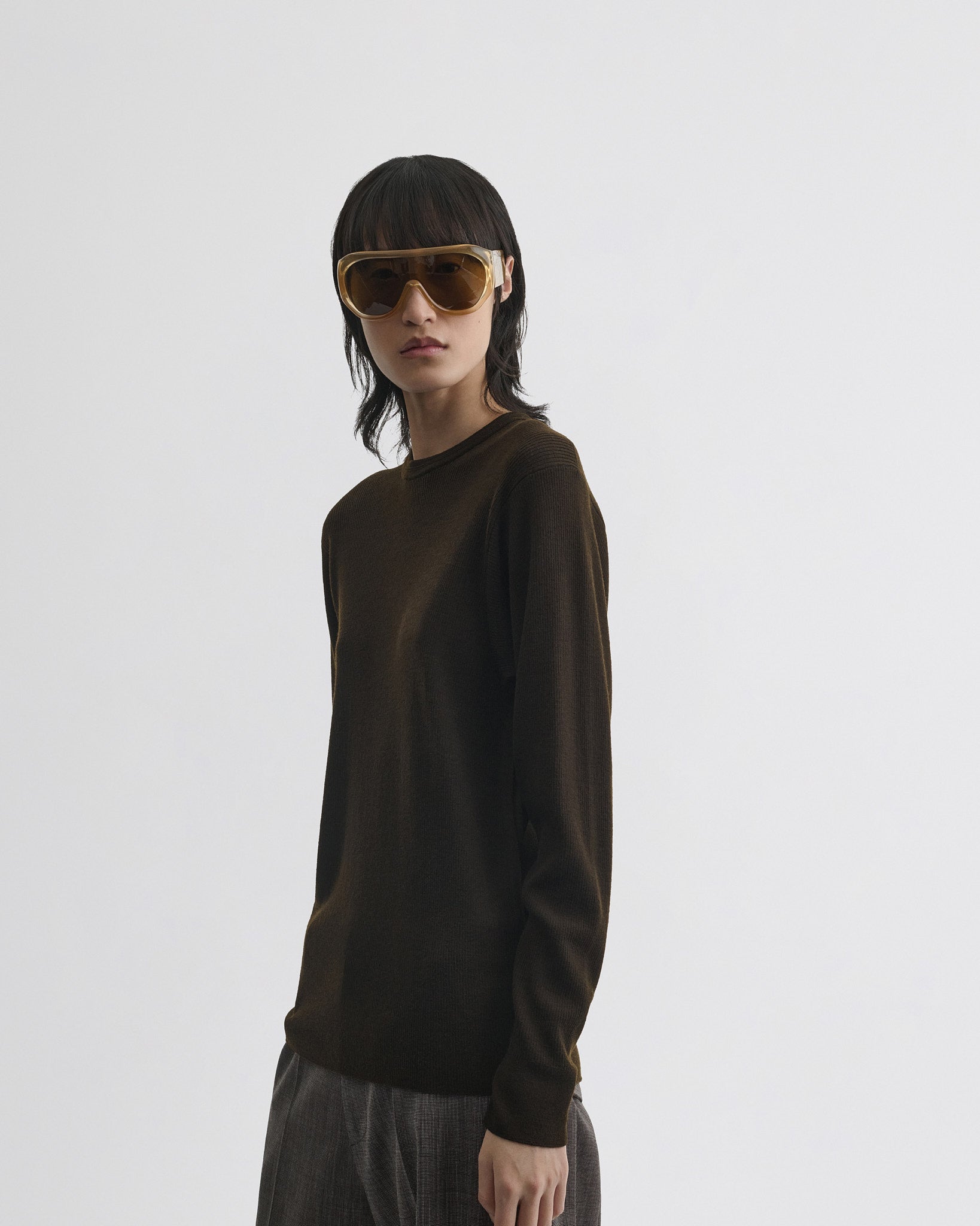 Side view of model wearing batwing crewneck in dark khaki wool.