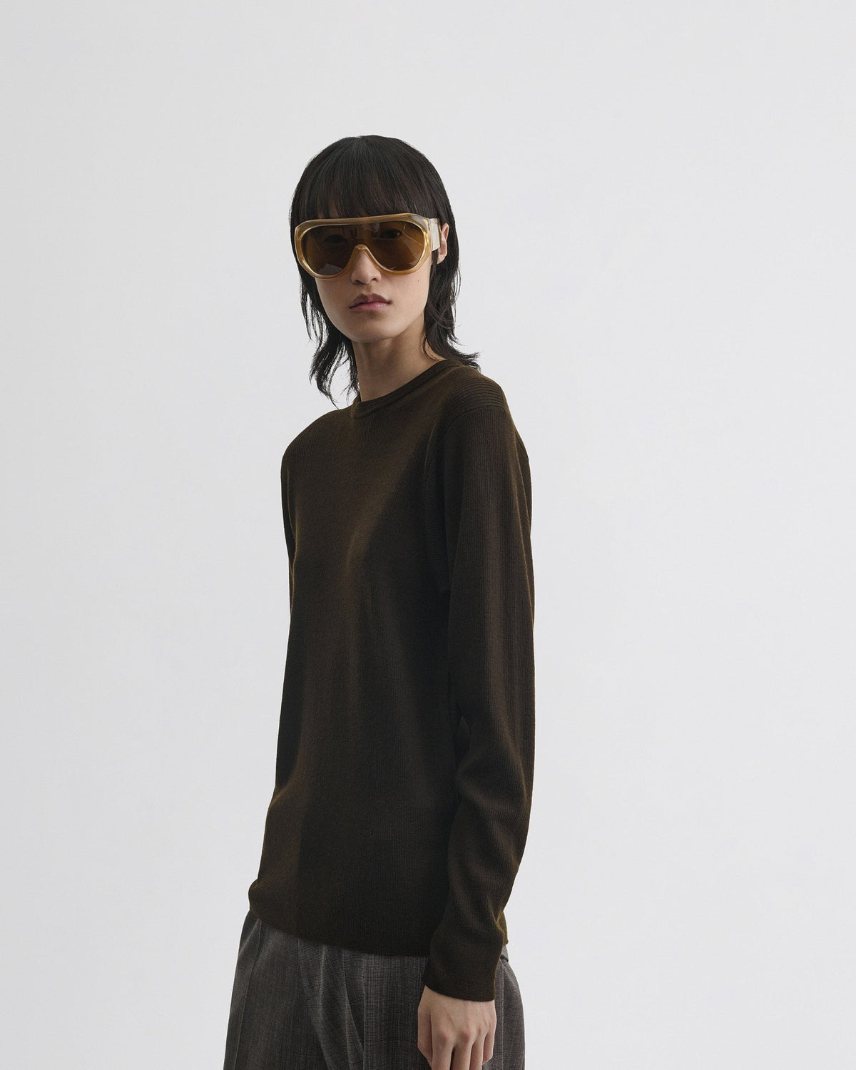Close angled view of model wearing RIBBED LONG SLEEVE CREWNECK in dark khaki wool