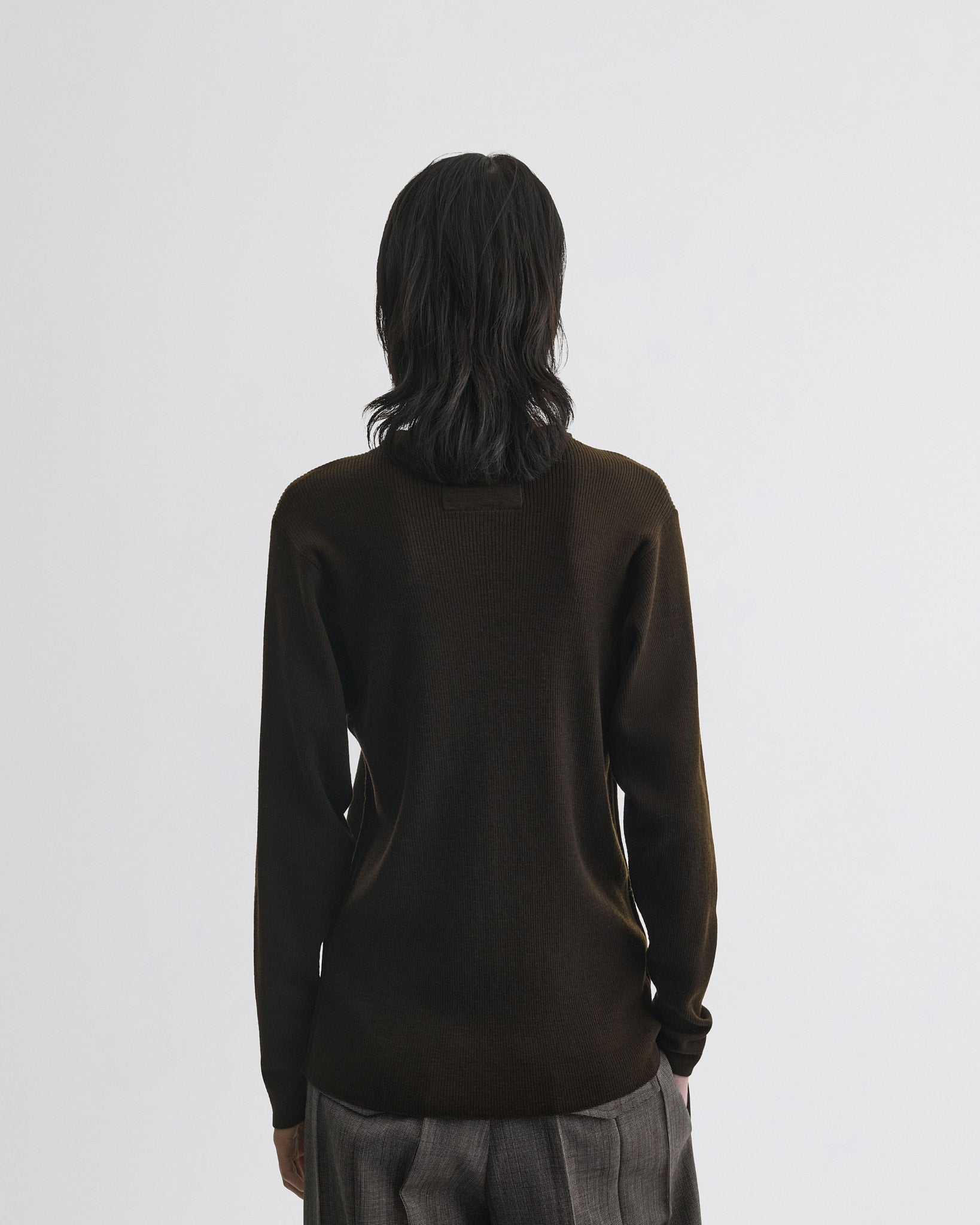 Back view of model wearing batwing crewneck in dark khaki wool.