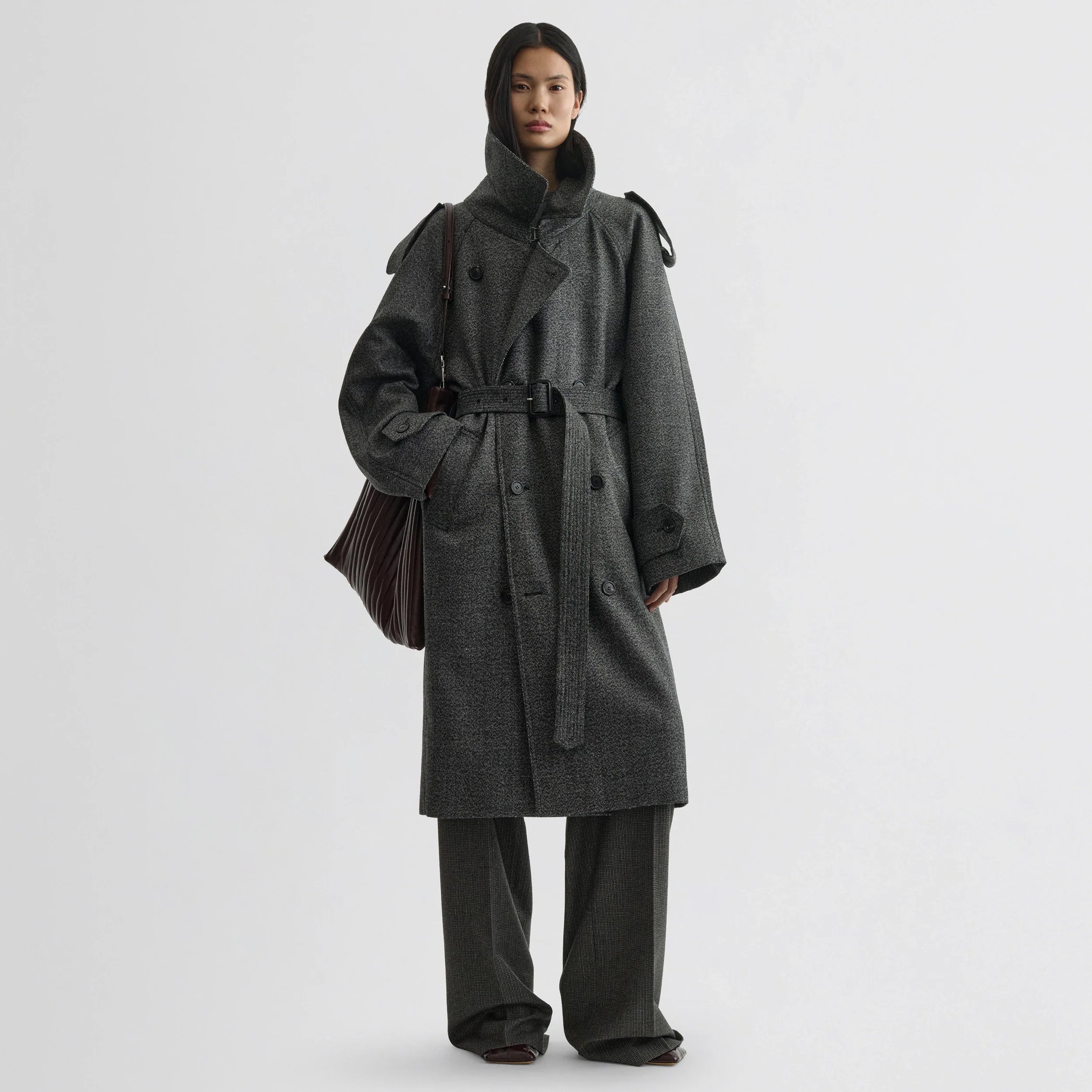 Front view of model wearing padded trench coat in salt and pepper wool.
