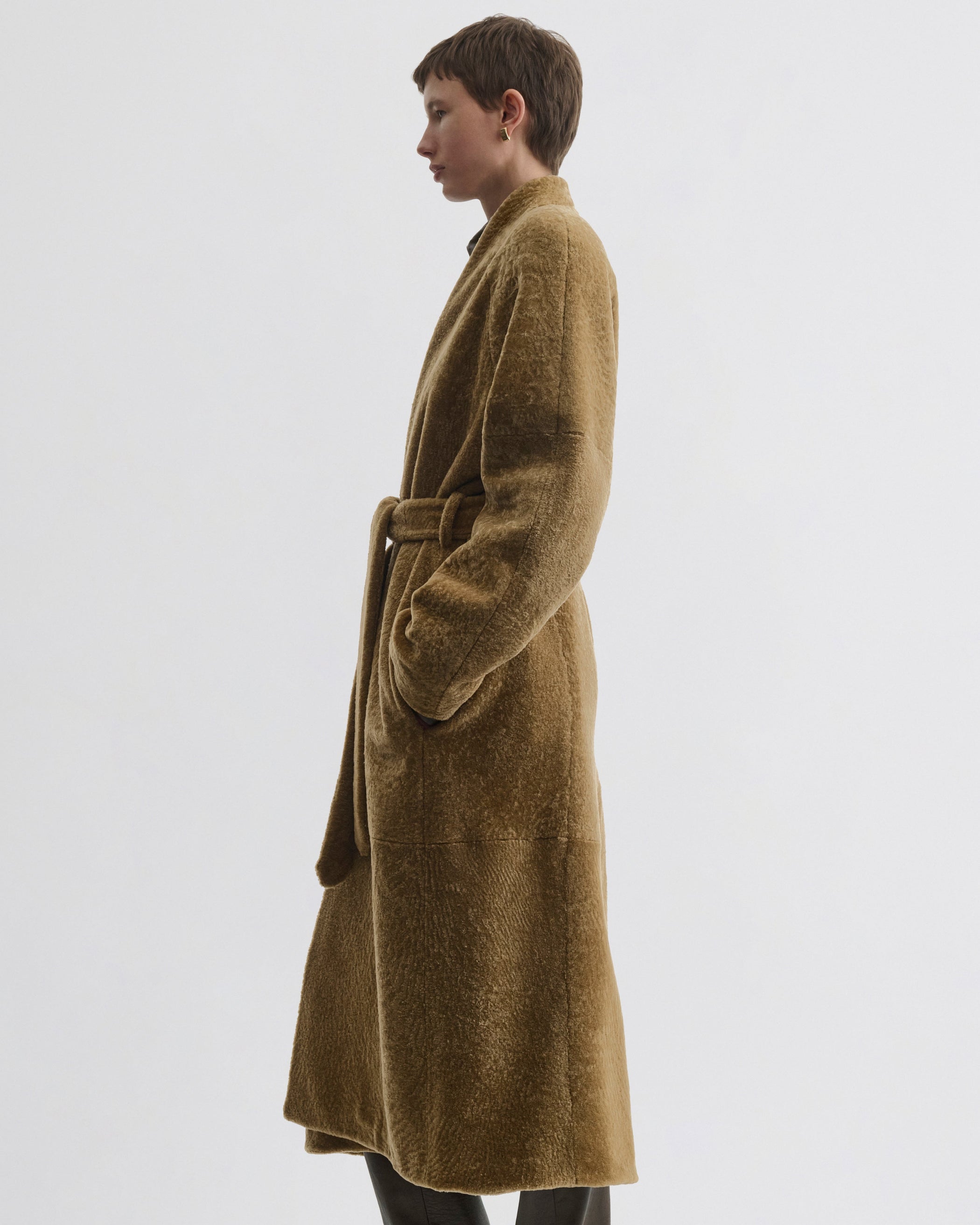 Side view of model wearing Shaved Robe Coat in tabac shearling