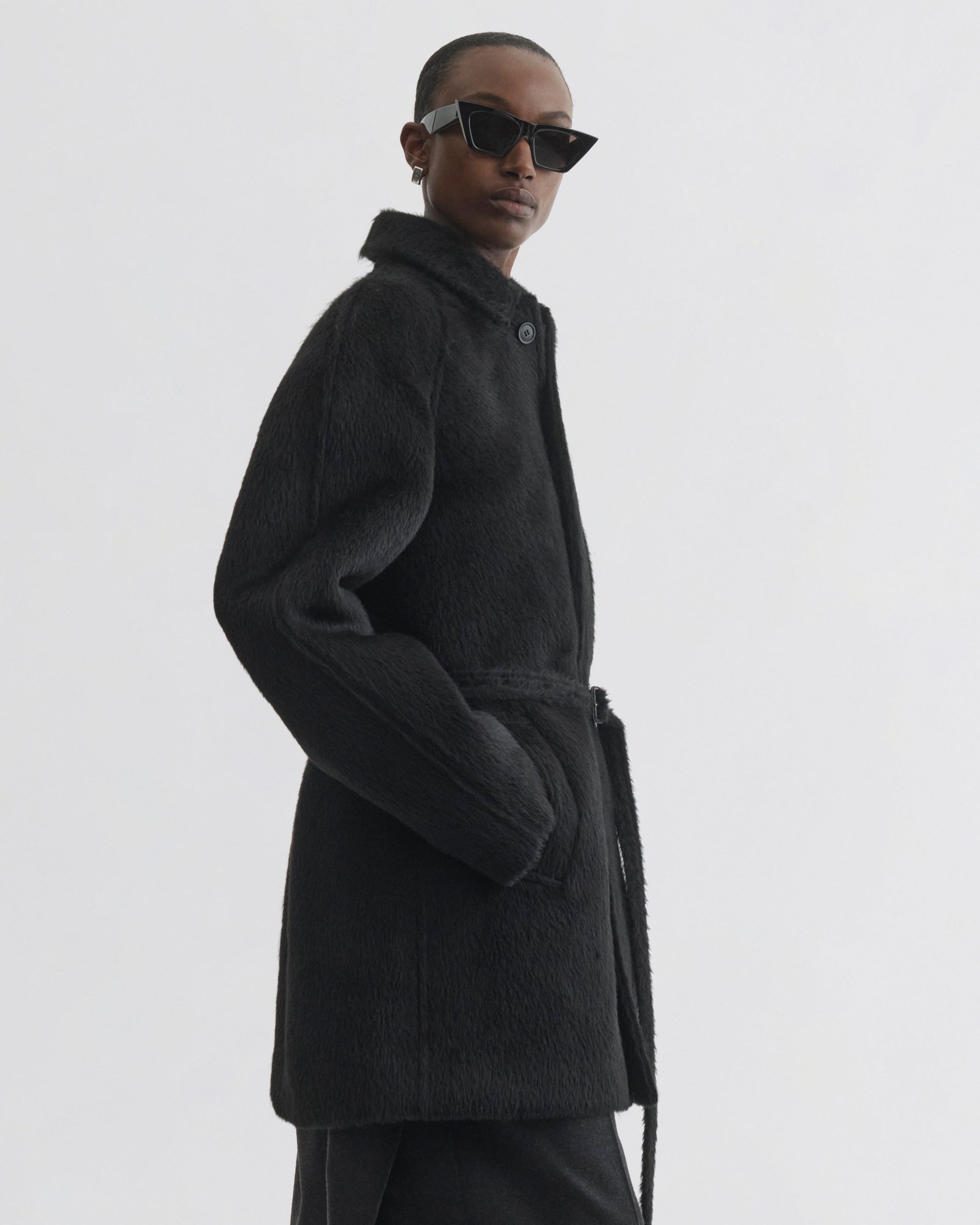 Side view of model wearing Cropped Car Coat in black alpaca wool