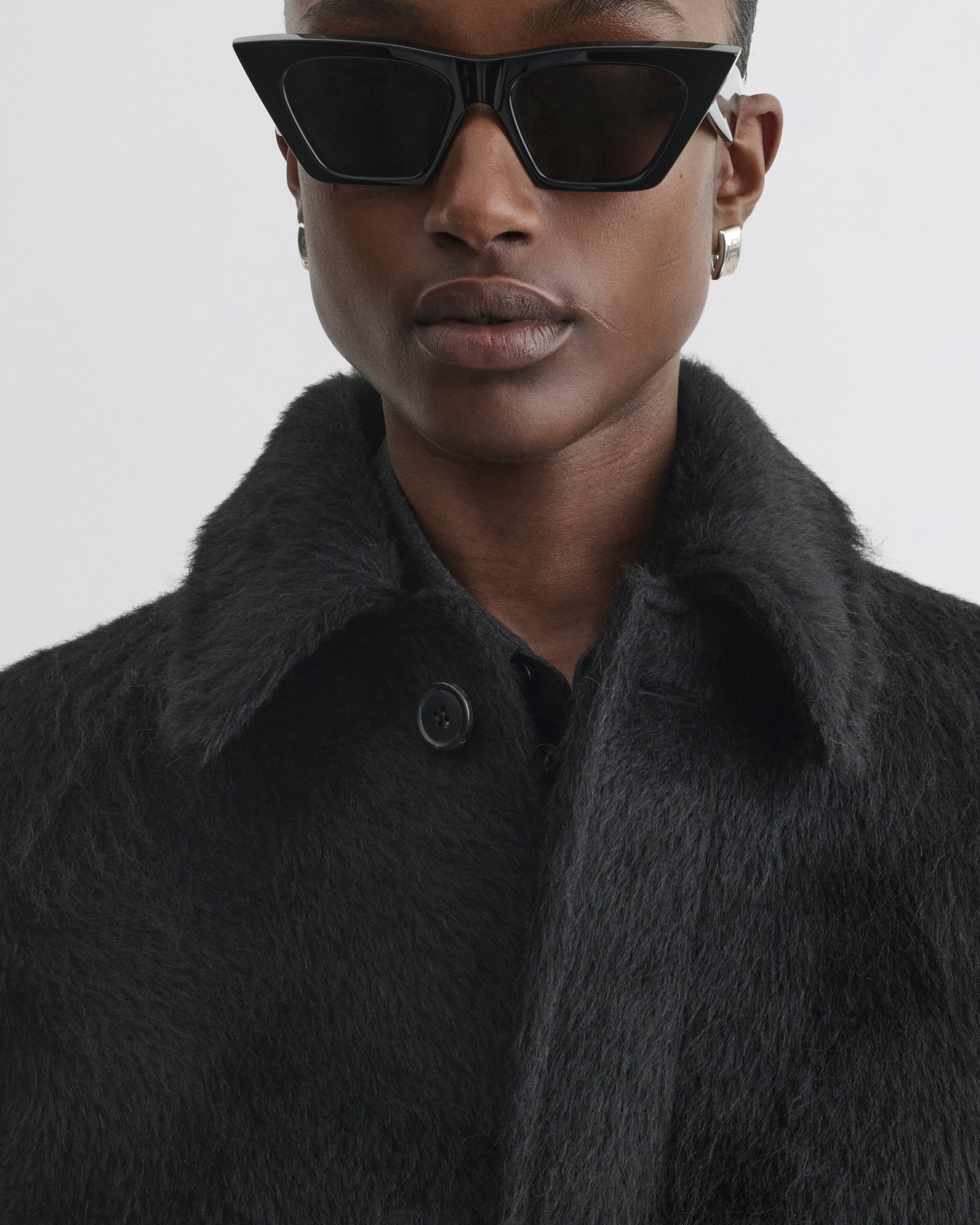 Close up view of model wearing Cropped Car Coat in black alpaca wool