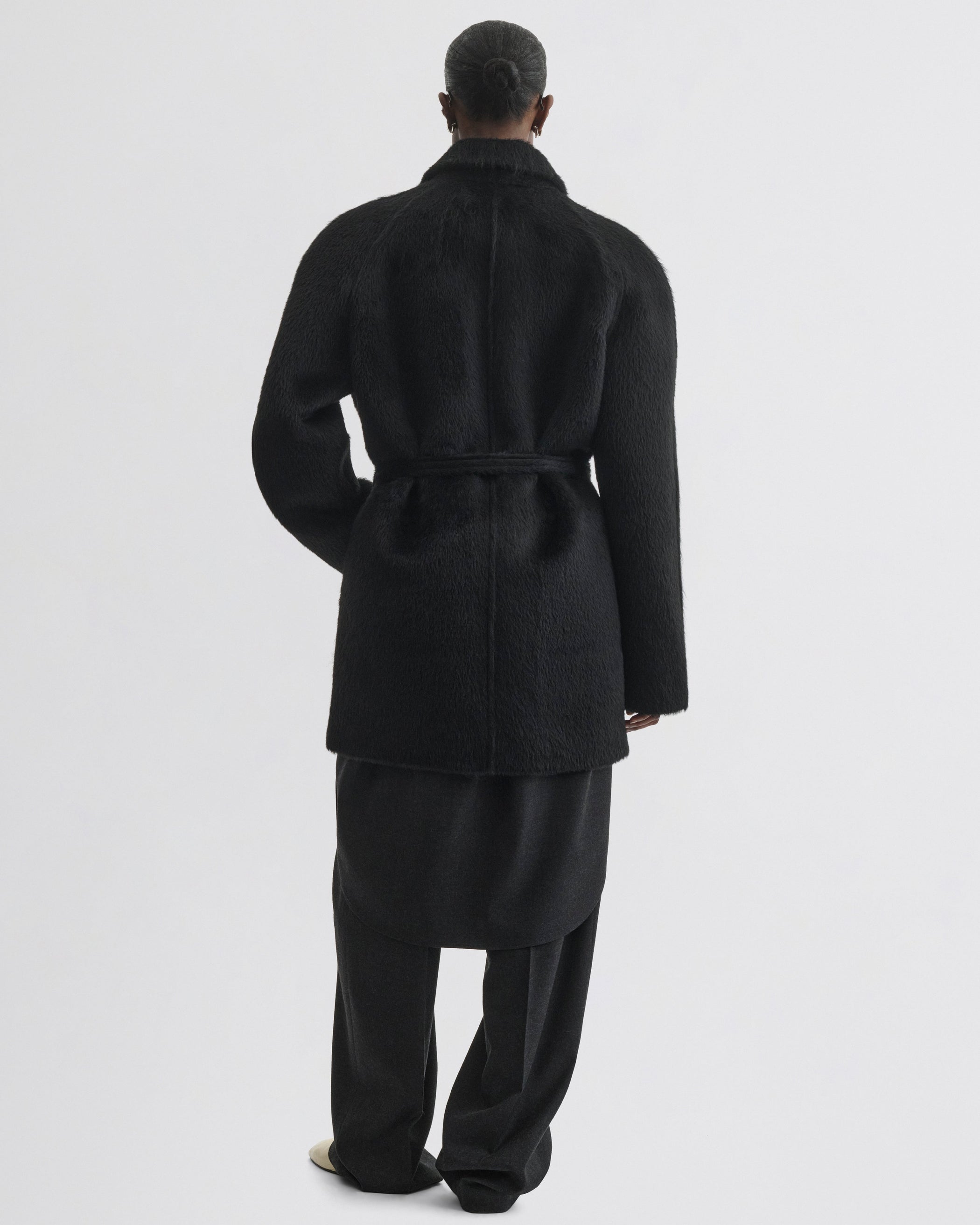 Back view of model wearing Cropped Car Coat in black alpaca wool