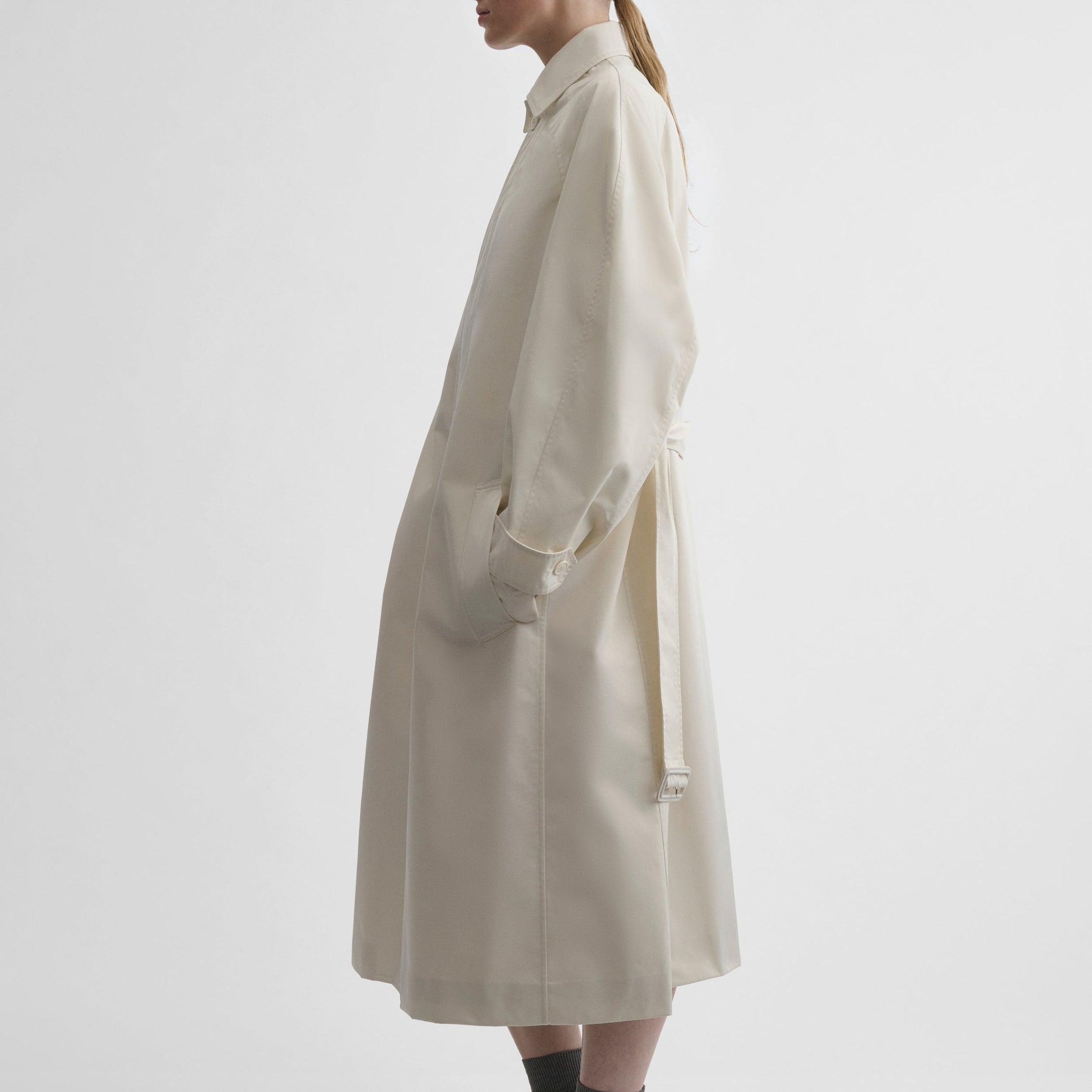 Side view of model wearing COMFY CAR COAT in white blonde technical twill