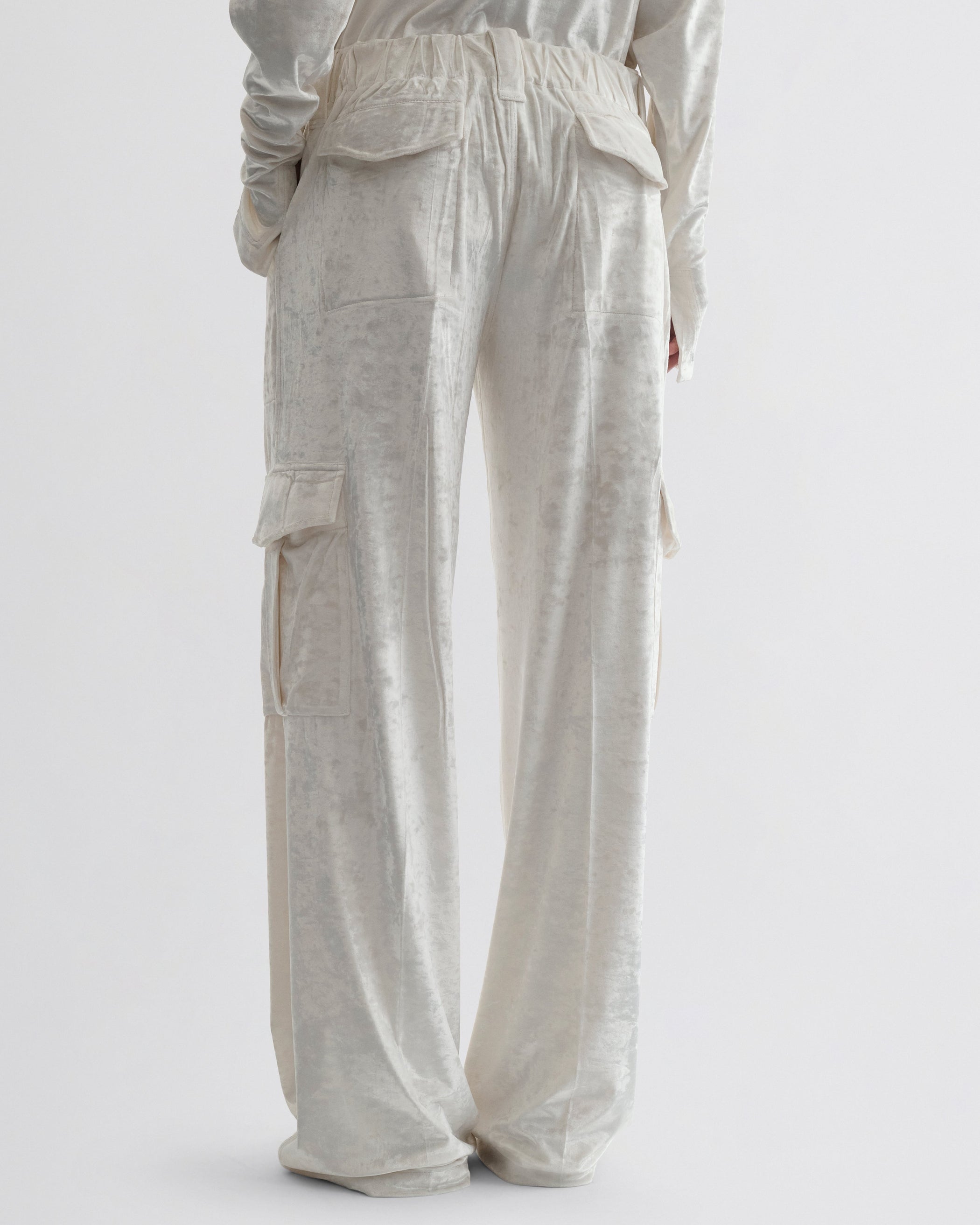 Back view of model wearing LIQUID CARGO TROUSERS  in white crushed velvet