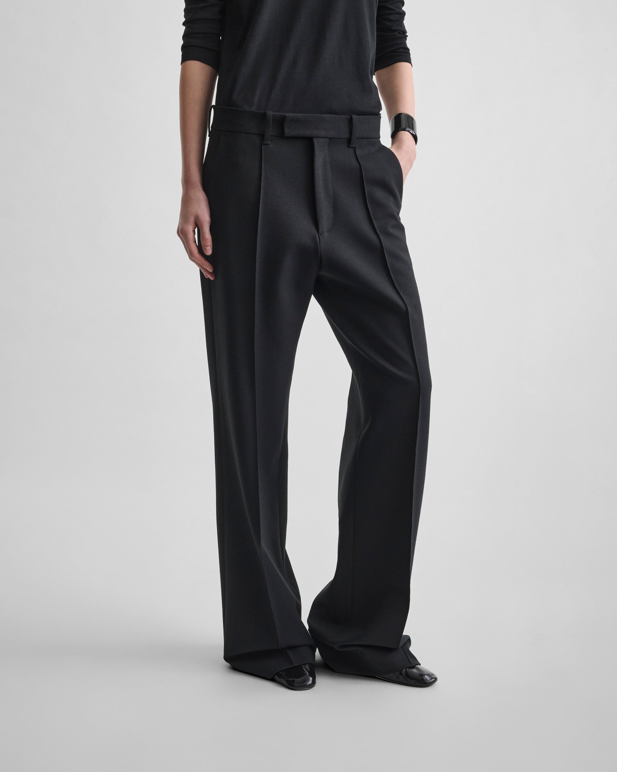Angled front view of model wearing BOYISH TAILORED TROUSERS in black wool