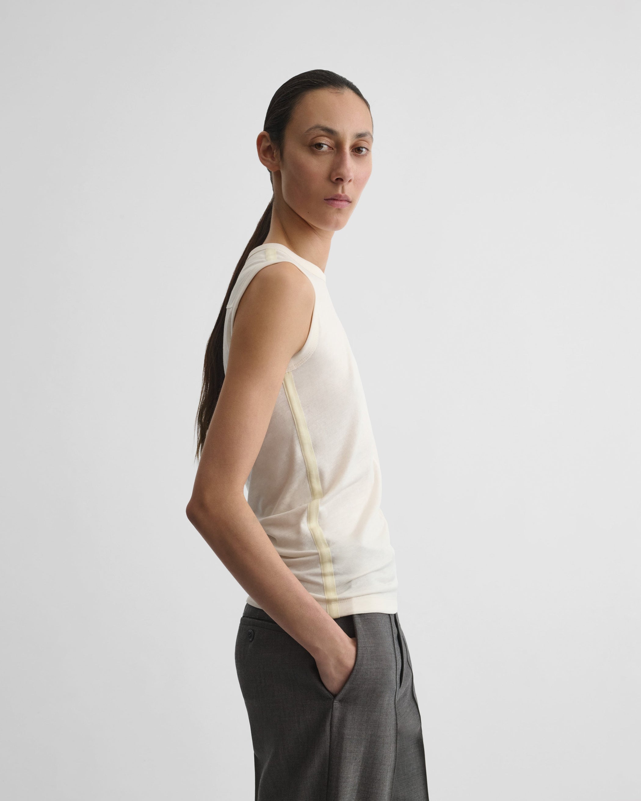 Side view of model wearing UNDERPINNING TANK TOP in ivory cotton