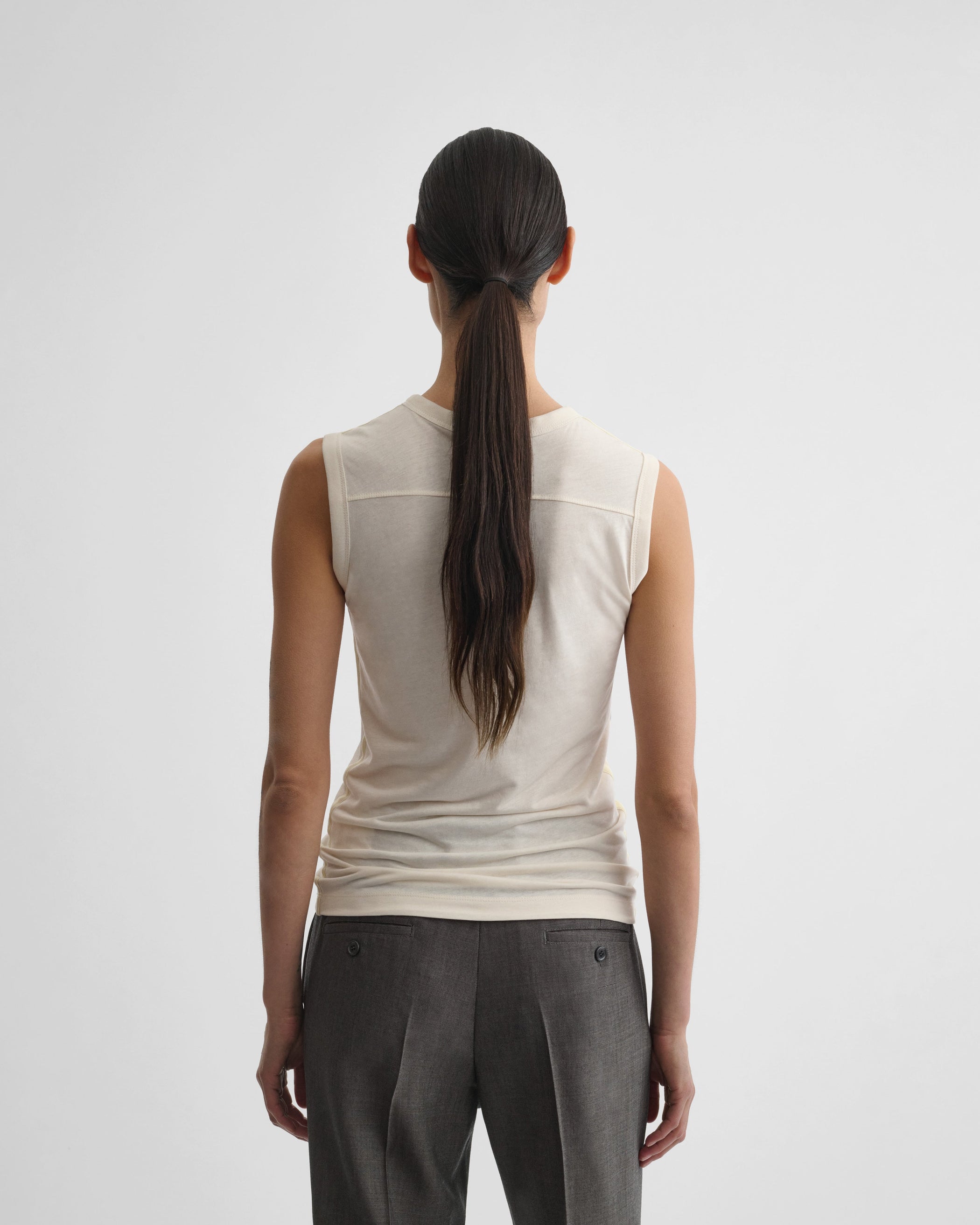 Back view of model wearing UNDERPINNING TANK TOP in ivory cotton