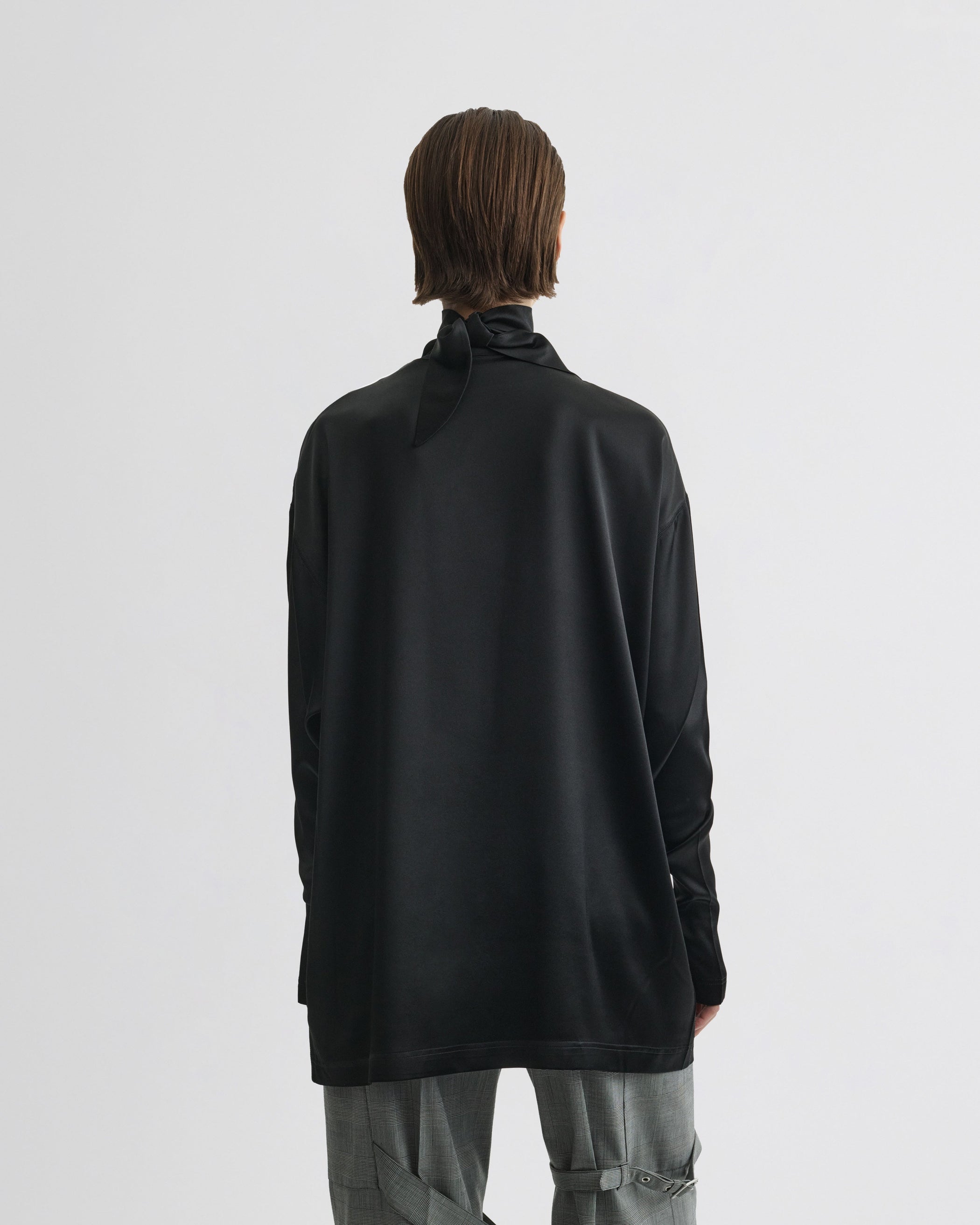 Back view of model wearing LIQUID KNOT COLLAR TOP in black silk
