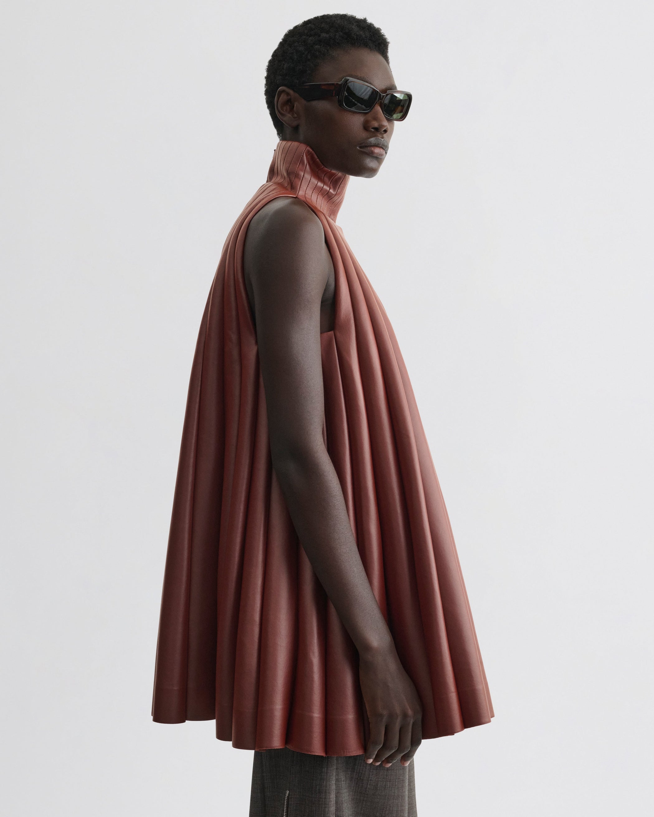 Side view of model wearing Accordion Top in brick bonded jersey