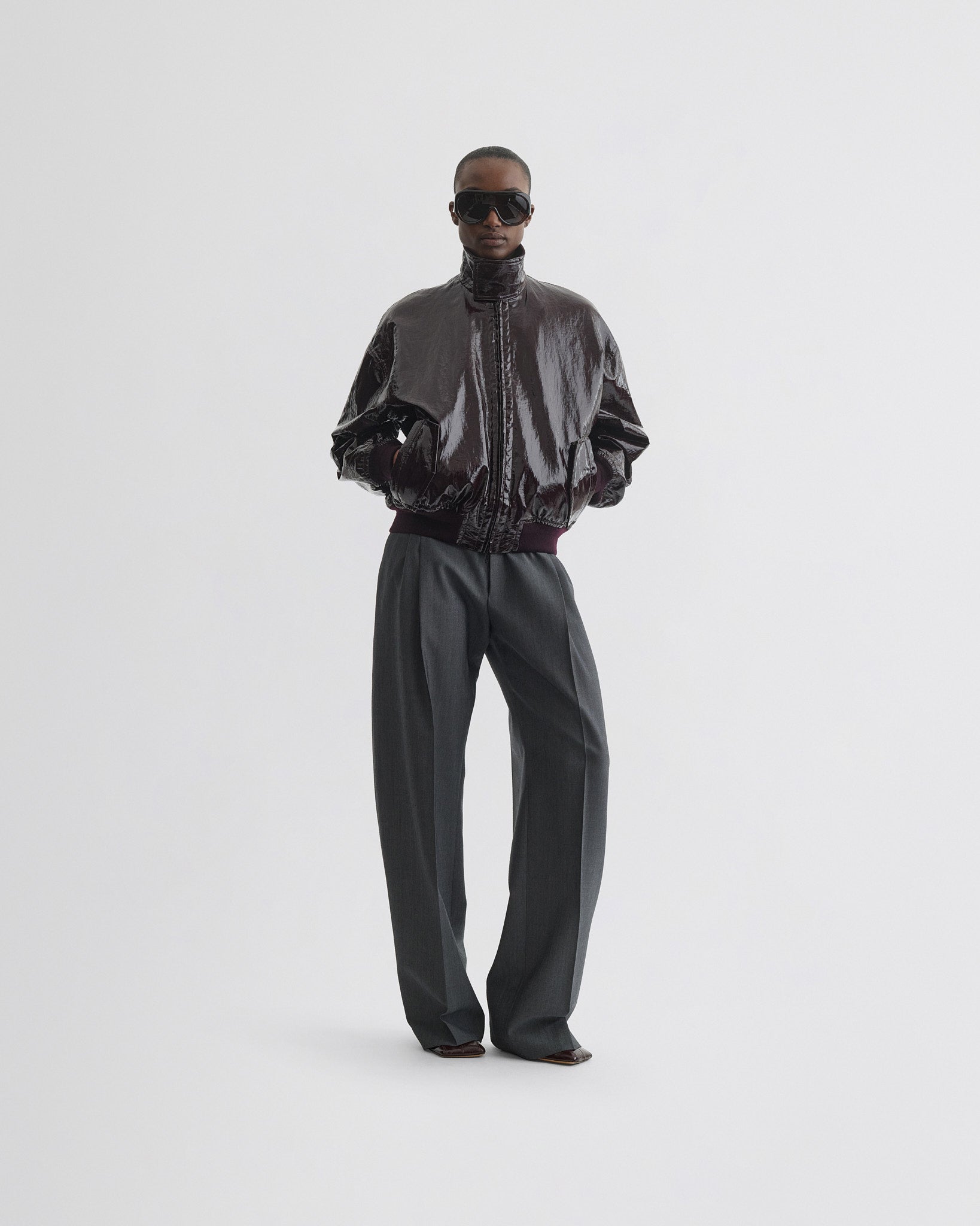 Front view of model wearing golf jacket in burgundy linen canvas.